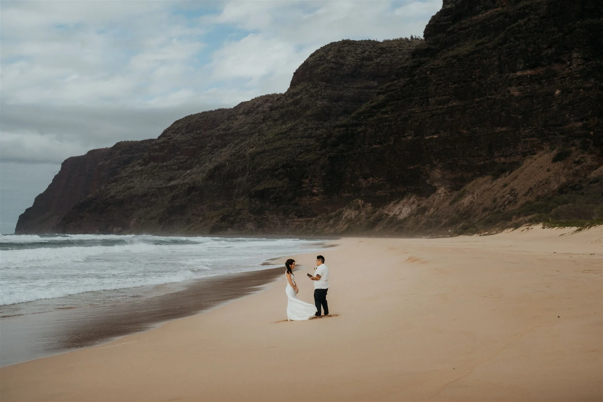Brides read personal vows on the beach during their elopement in Hawaii