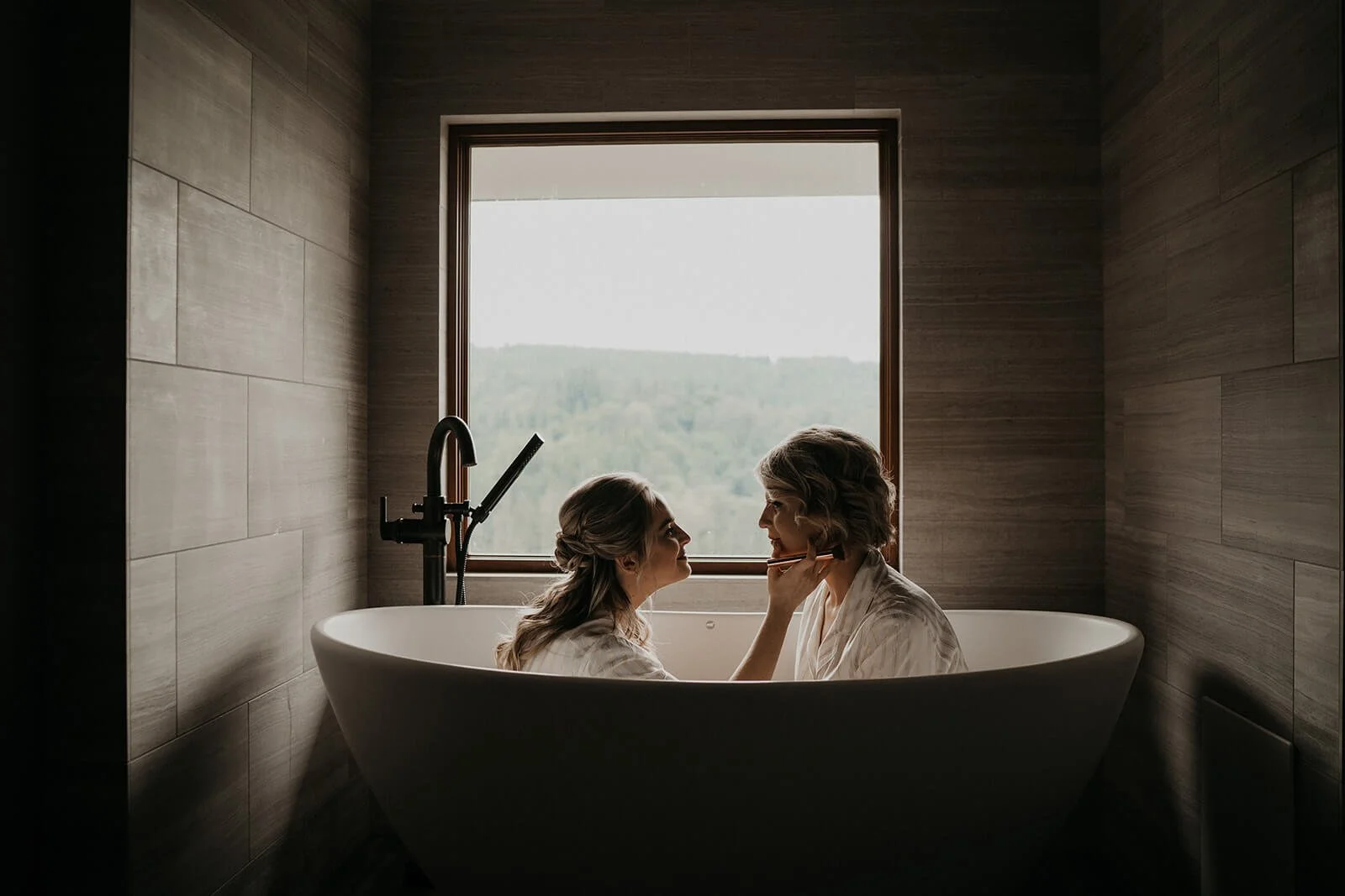 Two brides sitting in a bathtub during their Snoqualmie Falls wedding