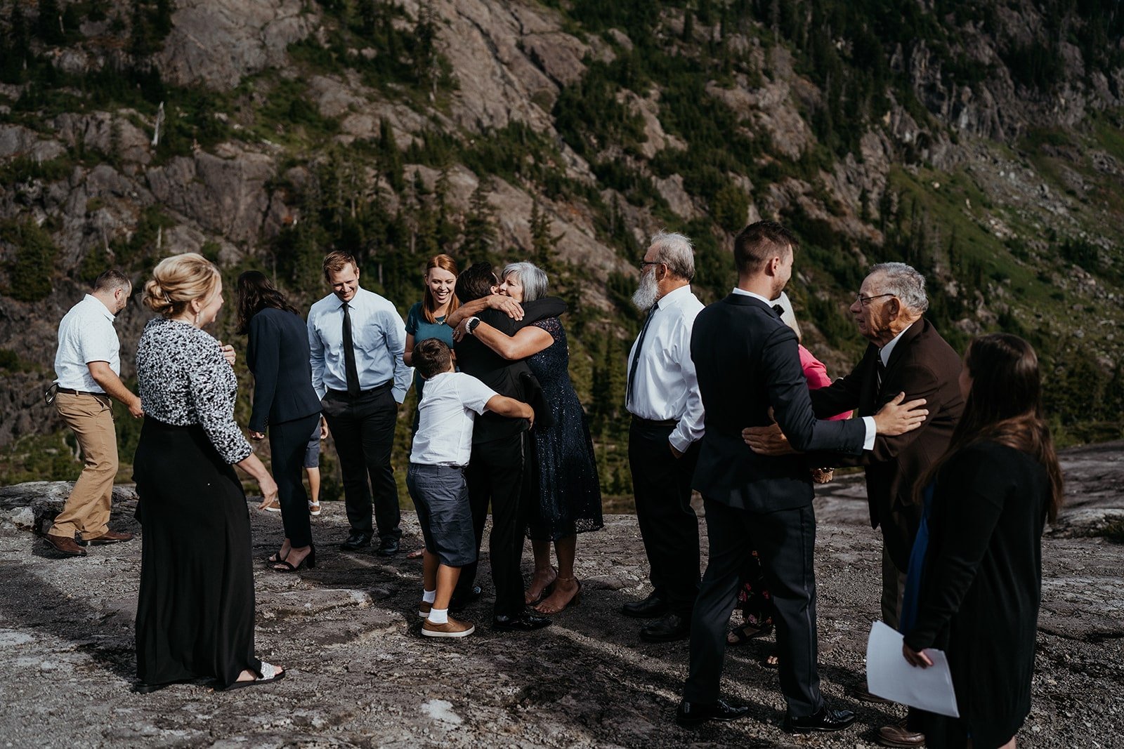 Grooms hug loved ones after eloping in the mountains in the North Cascades