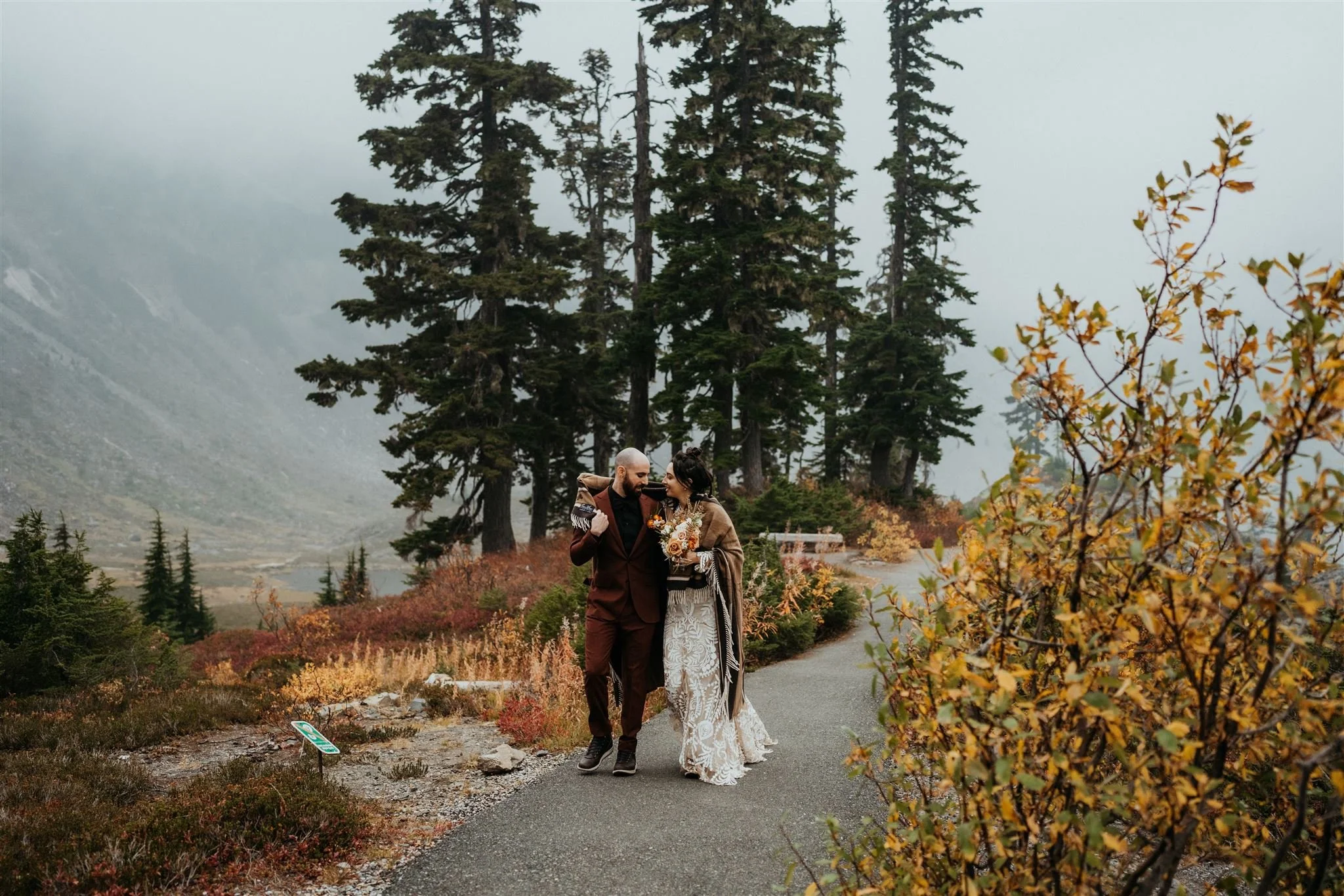 Bride and groom walking along a hiking trail during their fall Washington elopement