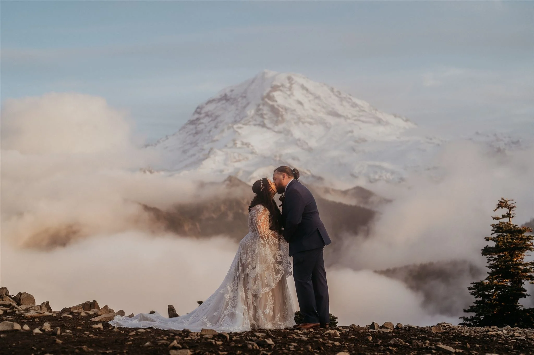 Bride and groom kiss on a mountain trail during their Mount Rainier National Park elopement