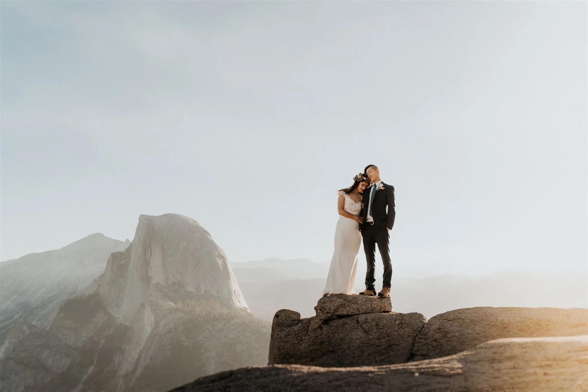 Bride and groom standing at the lookout at Glacier Point in Yosemite National Park