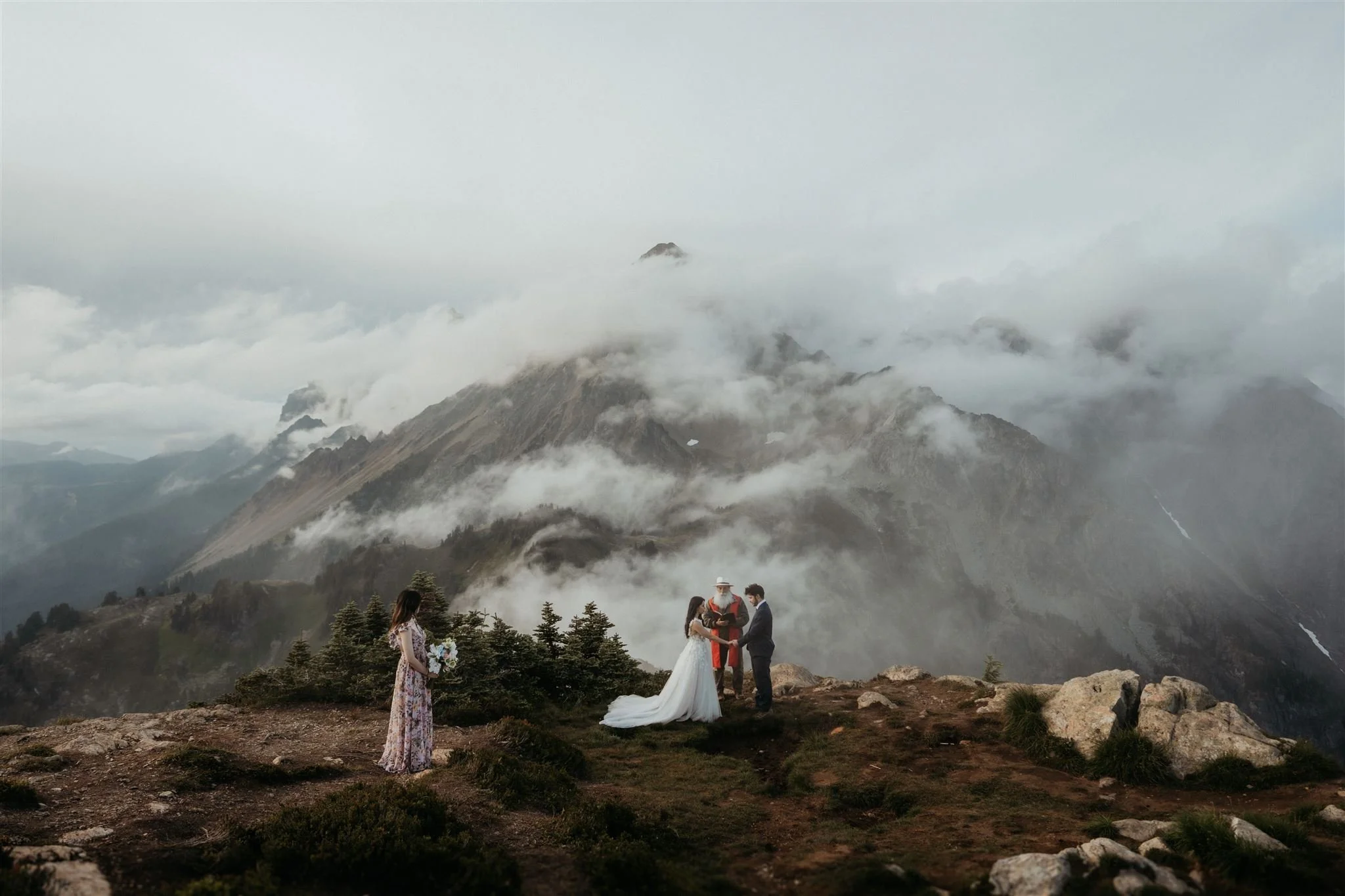 Bride and groom hold hands while eloping in Washington in the mountains