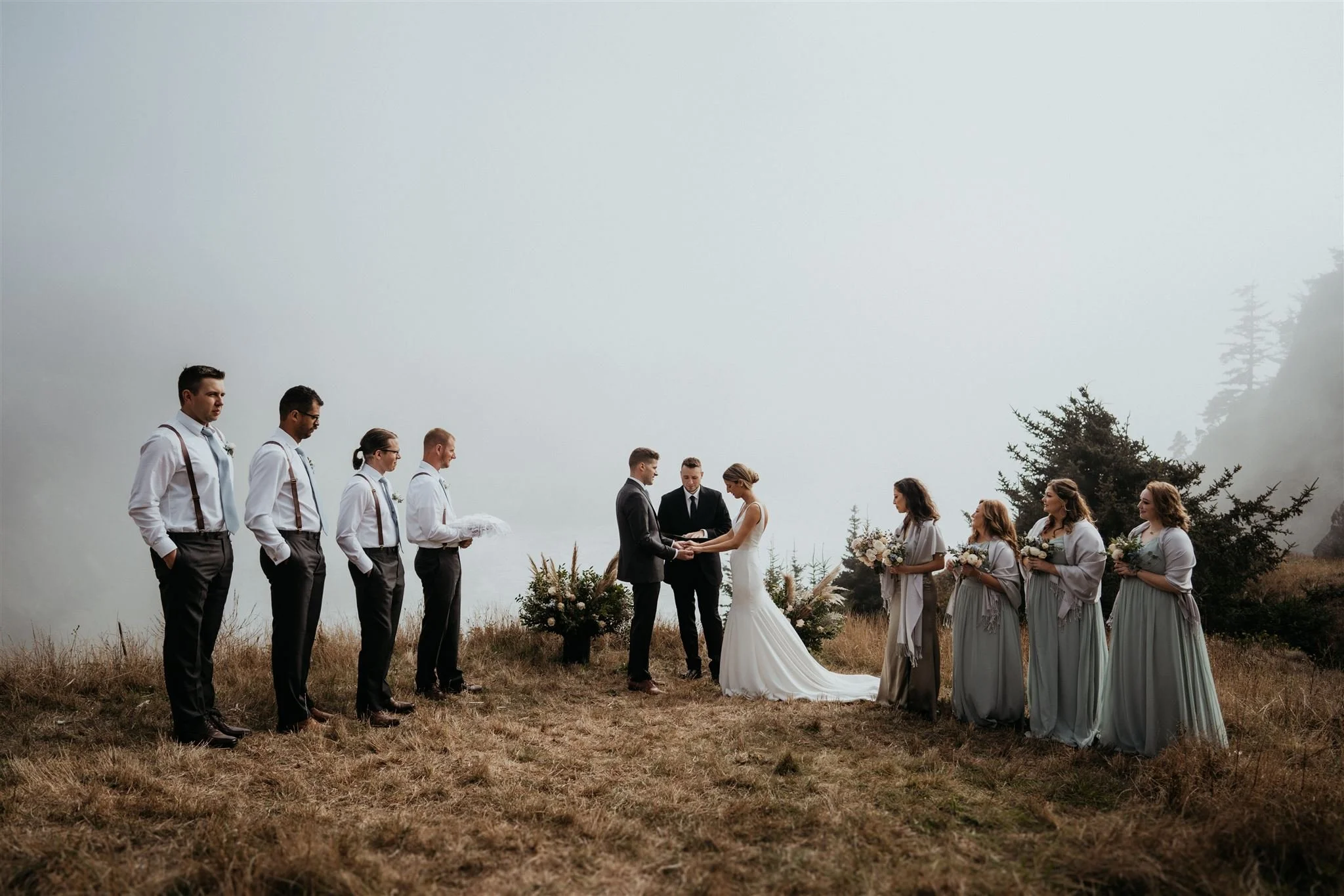 Bride and groom standing with their wedding party on the edge of the Oregon cliffs for their elopement ceremony