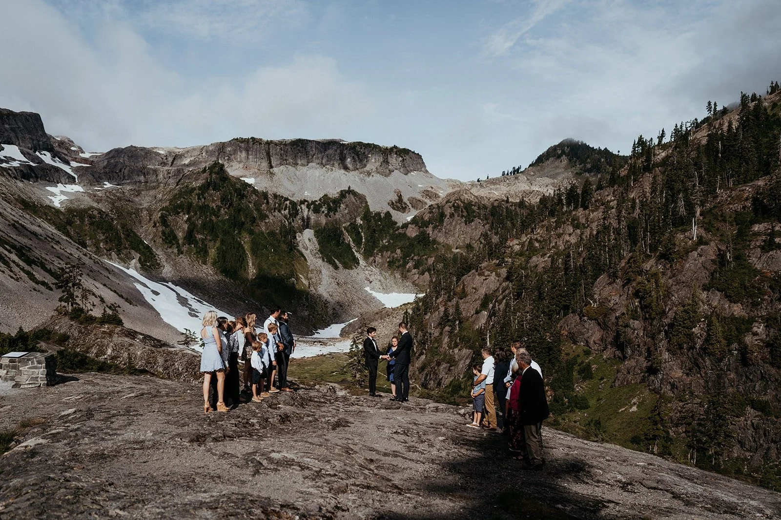 Two grooms elope on a mountain surrounded by family and friends
