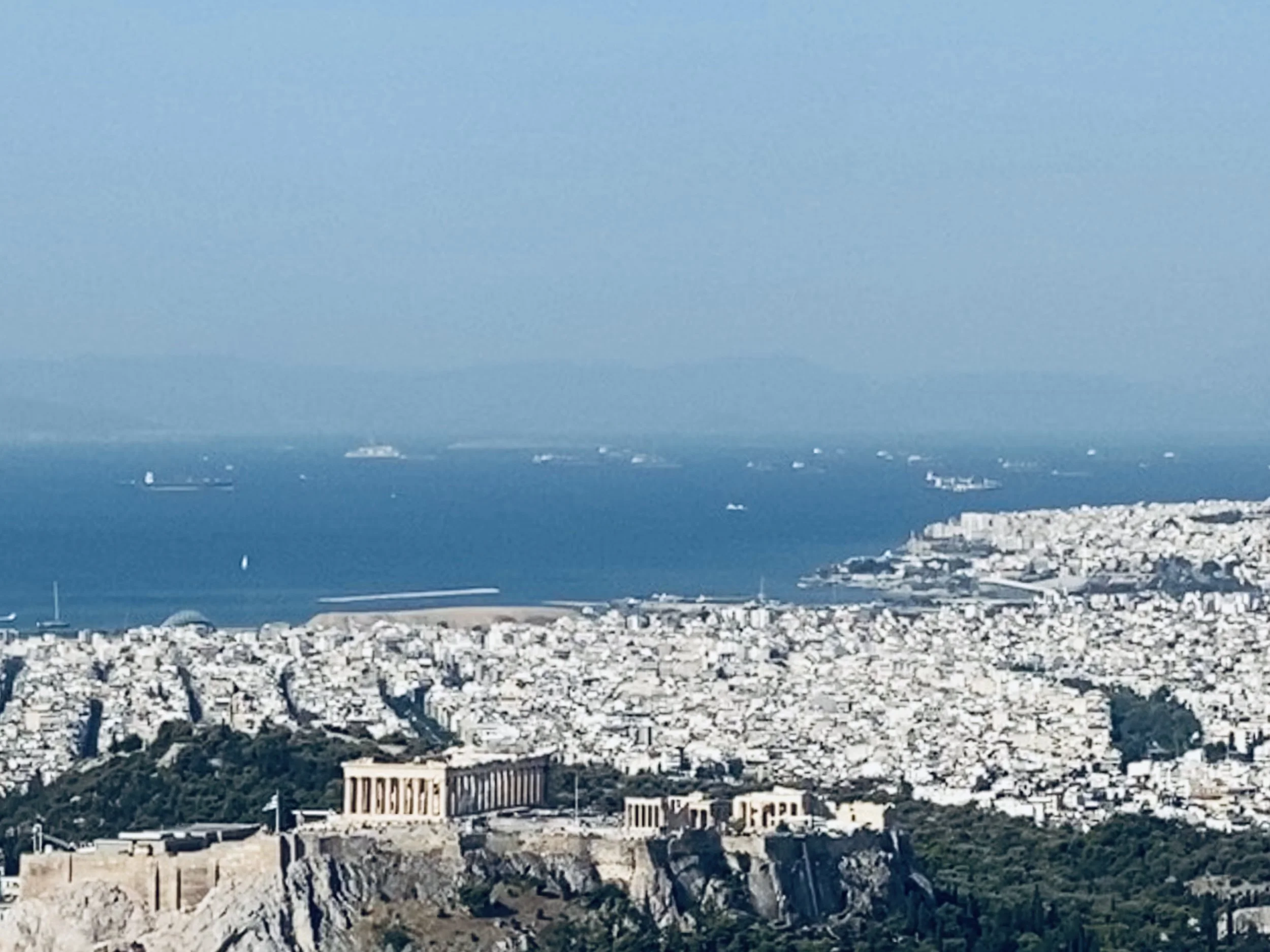 Aerial view of the Parthenon atop the Acropolis in Athens with the Aegean Sea.