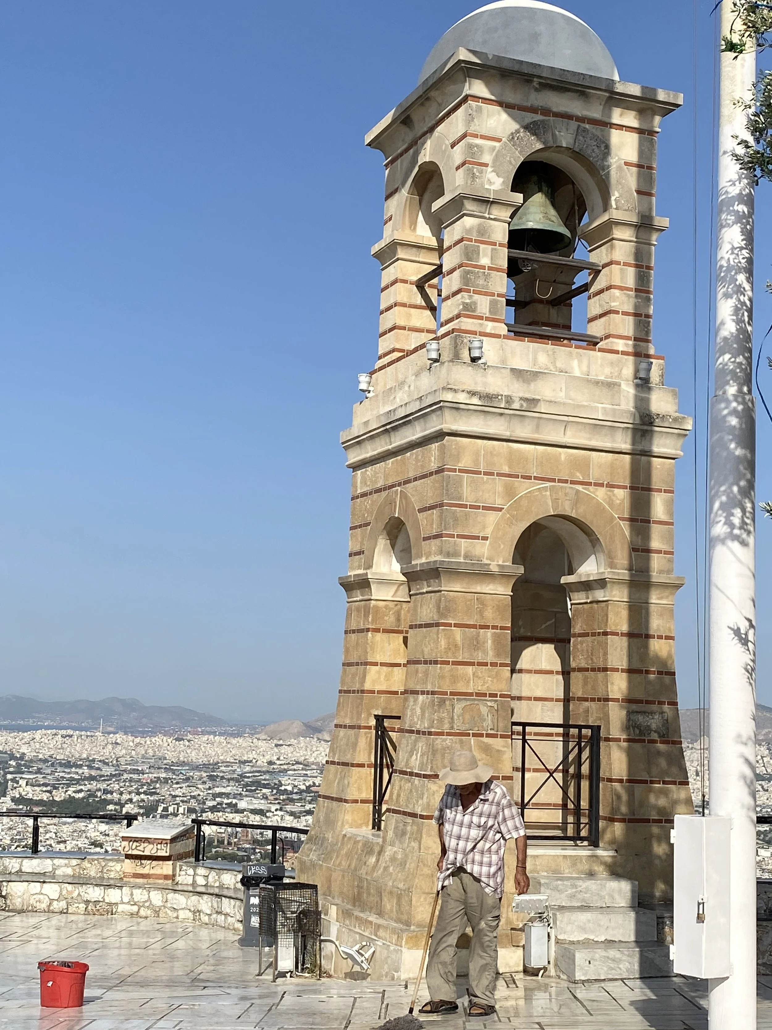 Man mopping marble floor on Mount Lykavittos, highest point of Central Athens