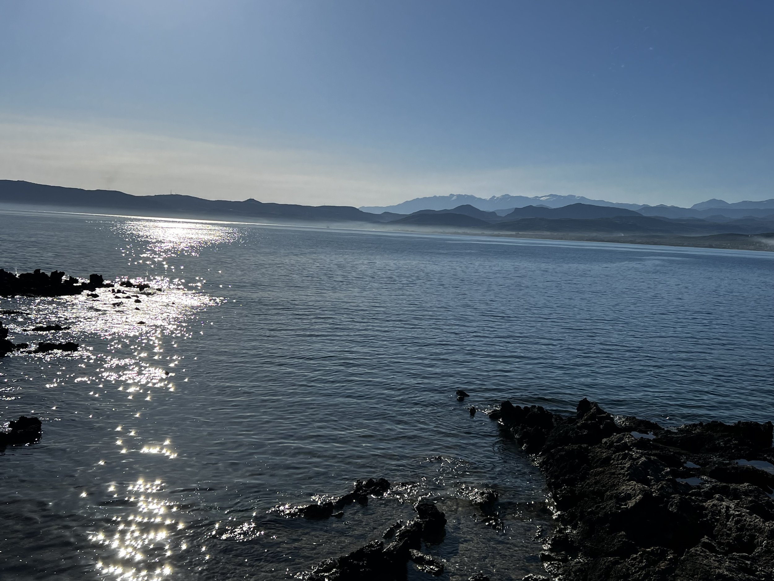 Sunlit sea reflecting rocky shoreline