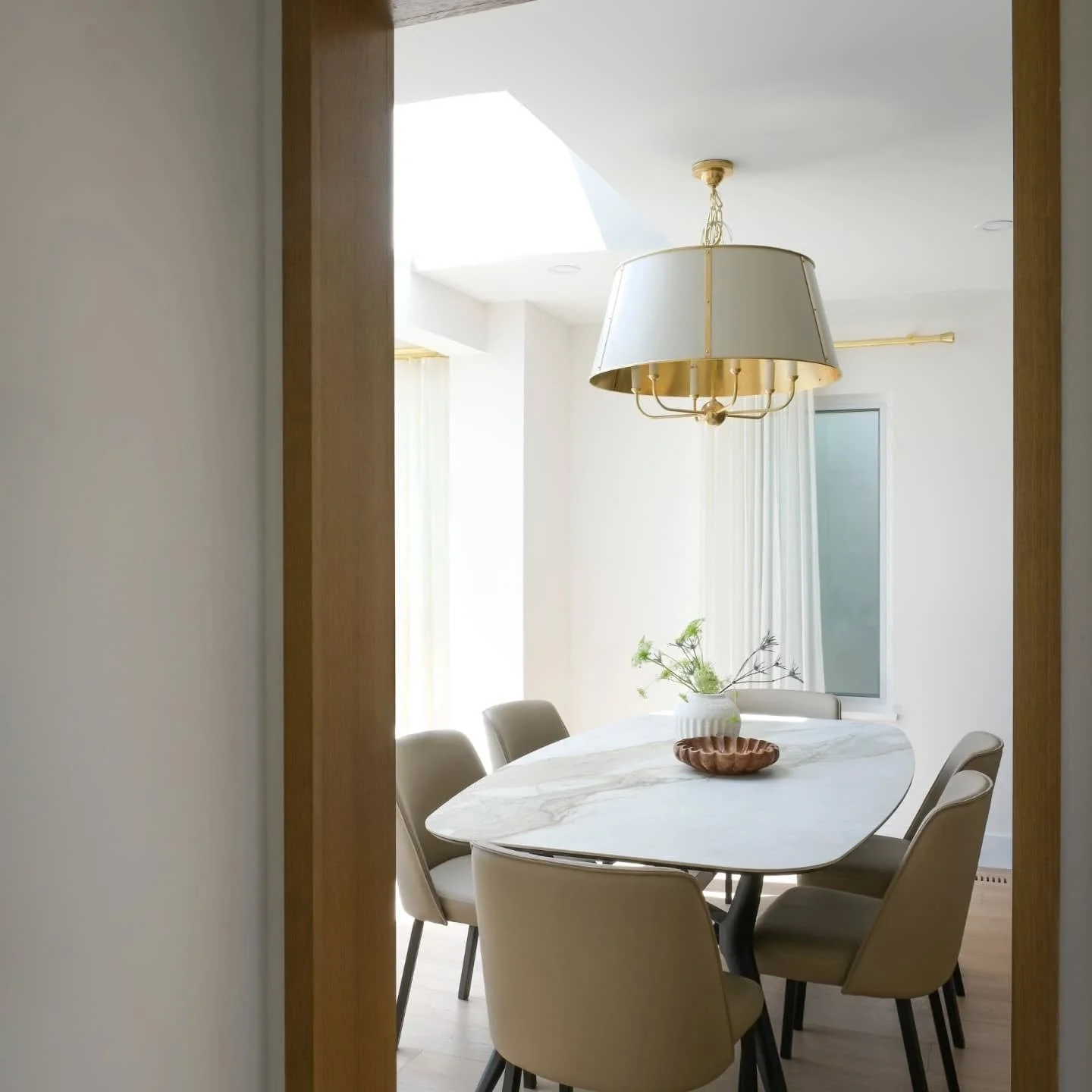 ✨ Step into timeless design ✨
This dining space captures modern sophistication with a classic touch &mdash; from the sculptural marble table and soft leather seating to the elegant brass chandelier and flowing floor-to-ceiling curtains that frame the