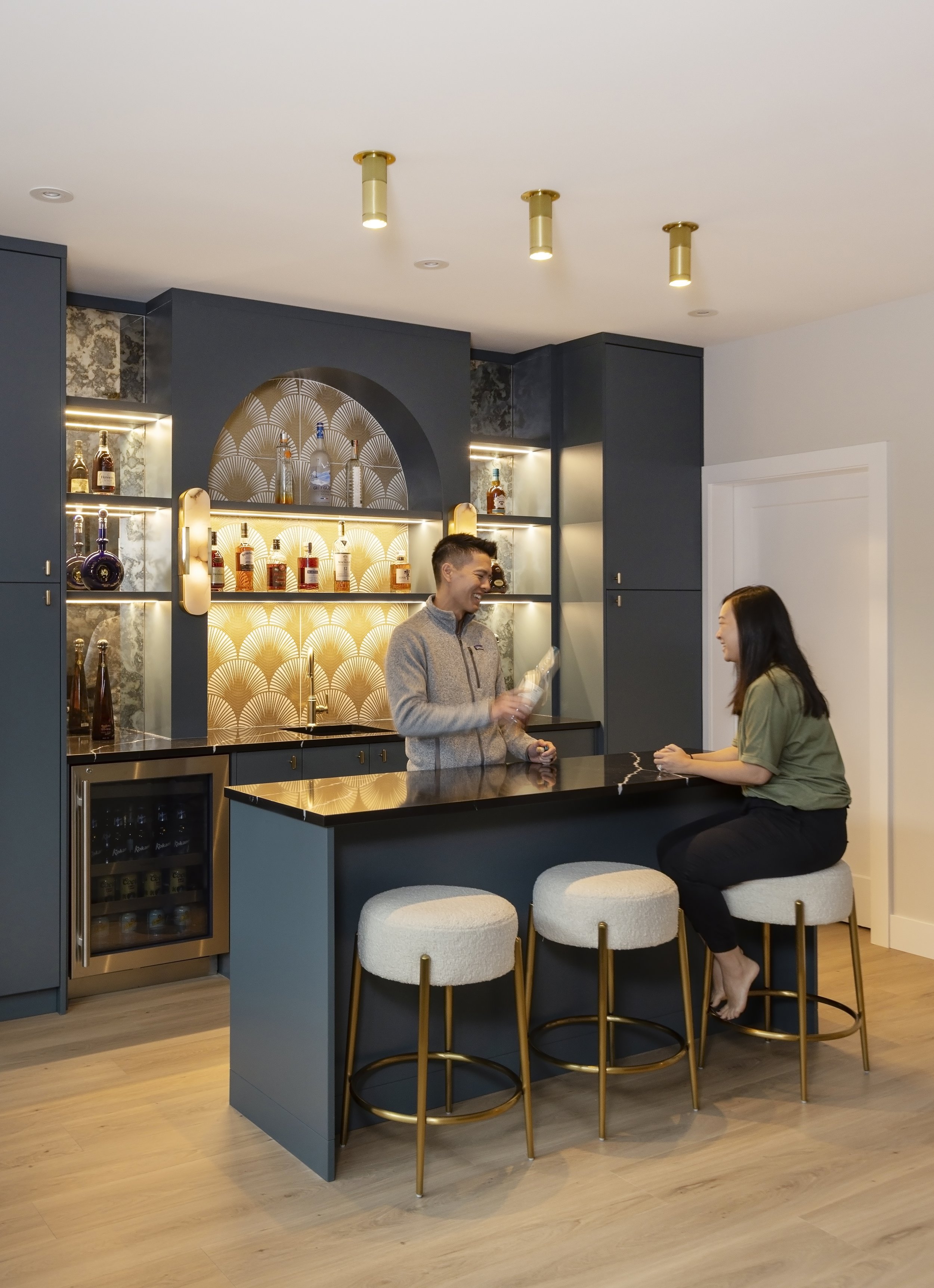 Custom home bar with navy cabinetry and arched glass display – Burnaby new build