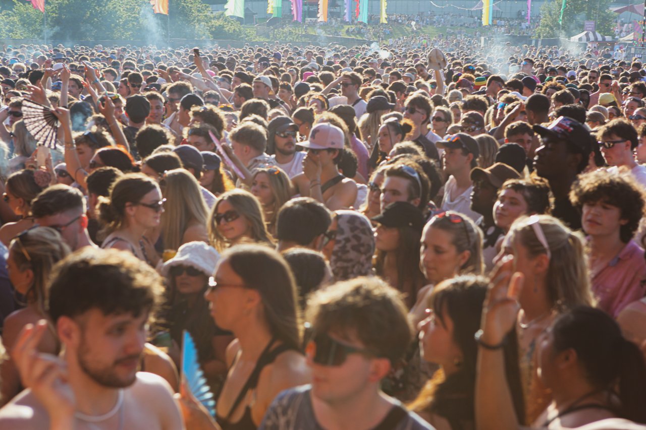 A busy crowd in a field under the sun