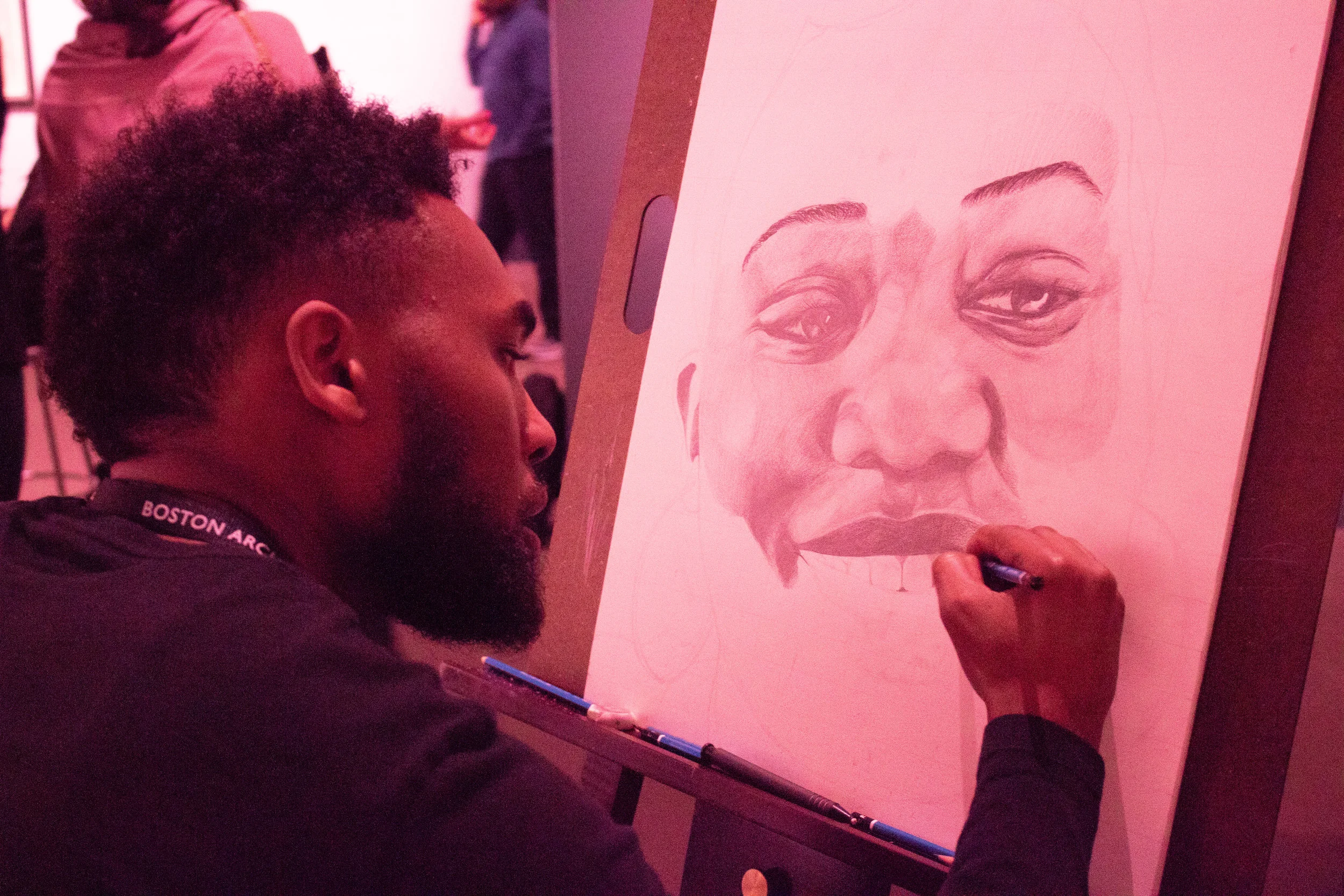 Mykael Damien Tucker works on a portrait of his sister.