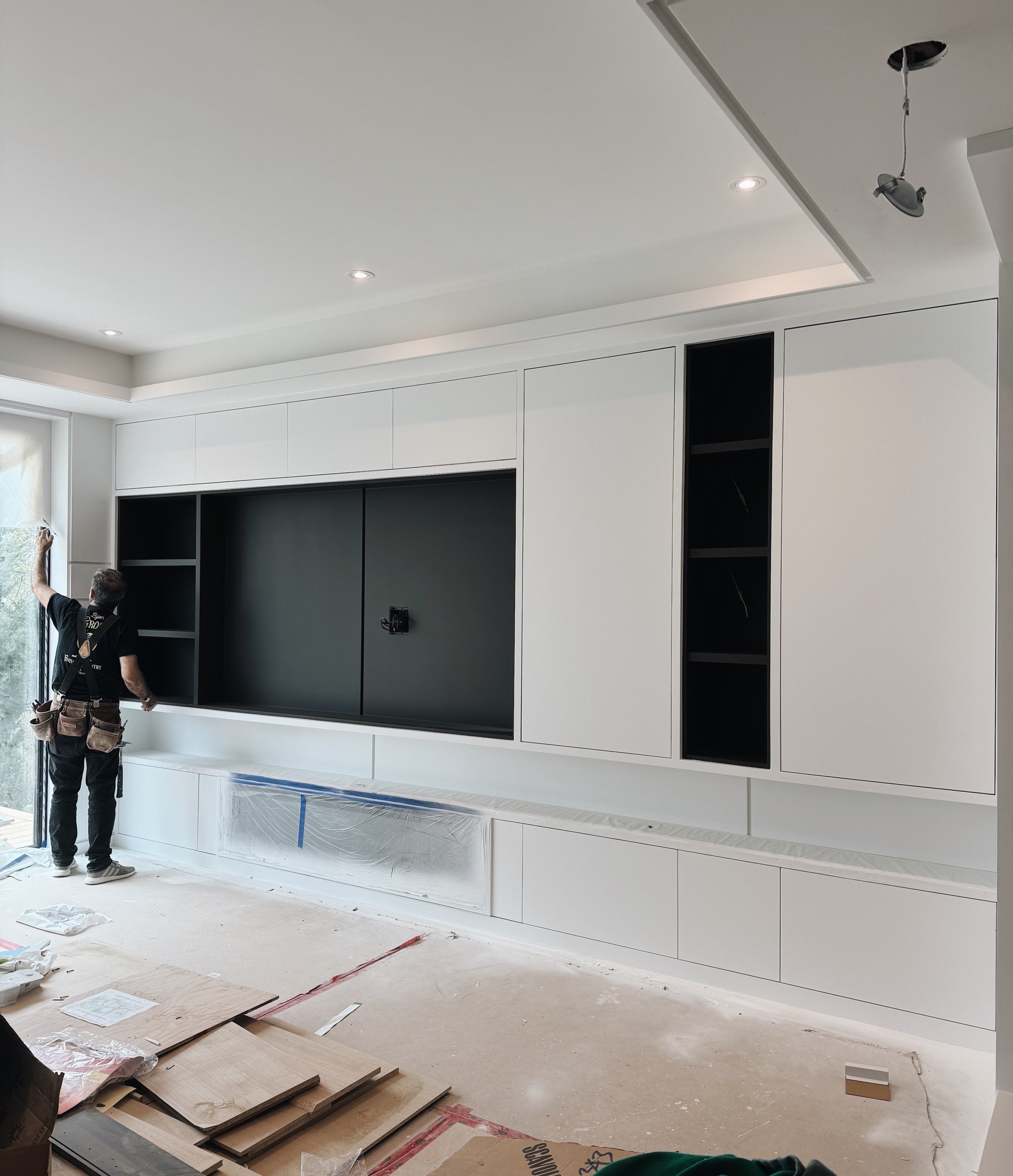 A look at a handmade modern TV wall unit, with a hidden front entrance closet and a shoe closet built into the design. 

#CustomMillwork #TVWallUnit #torontohomes