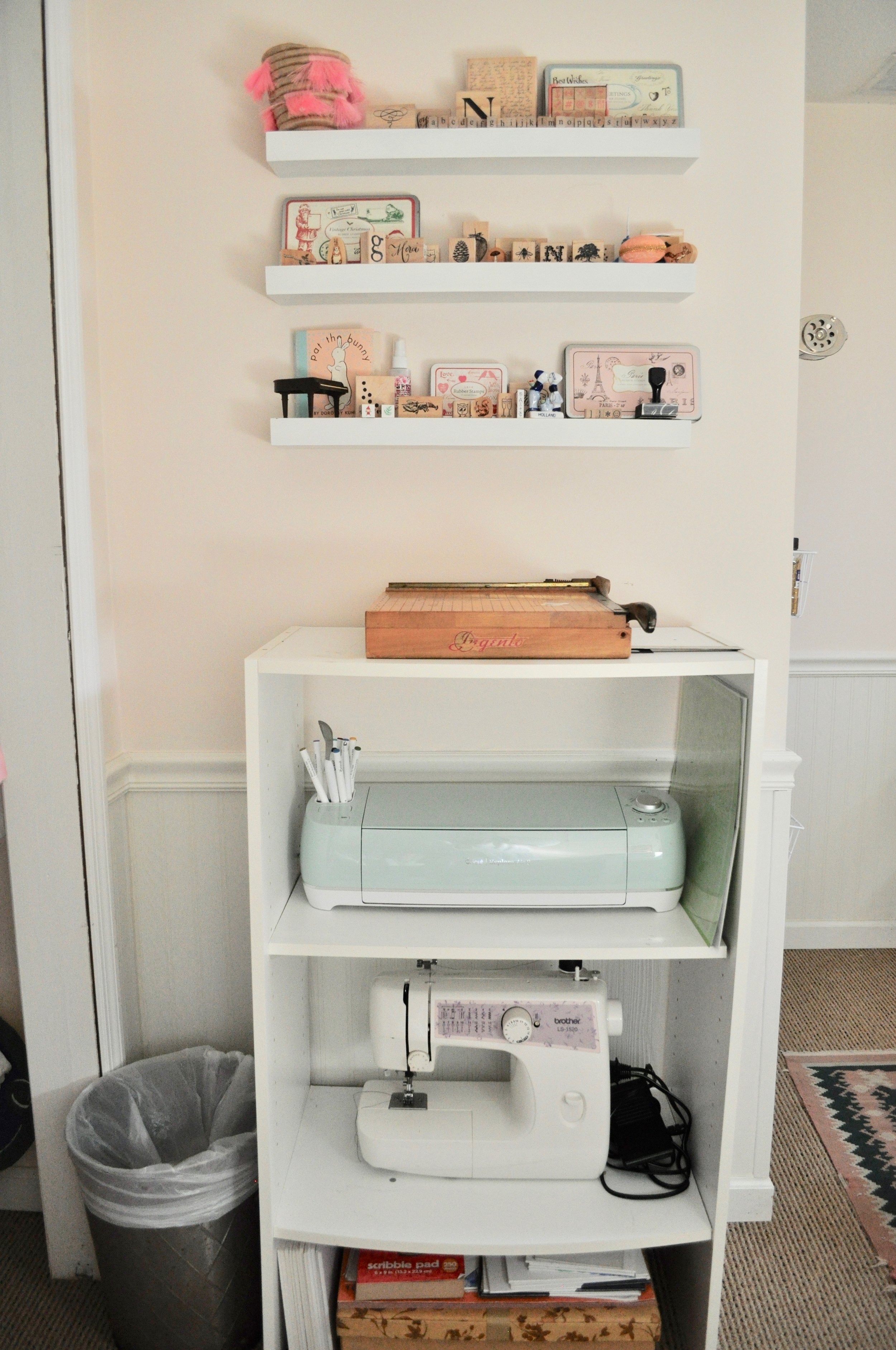 I can see all of my stamps displayed on floating shelves, and use this chopping block paper cutter at least once a week; shelves below house my Cricut and sewing machine
