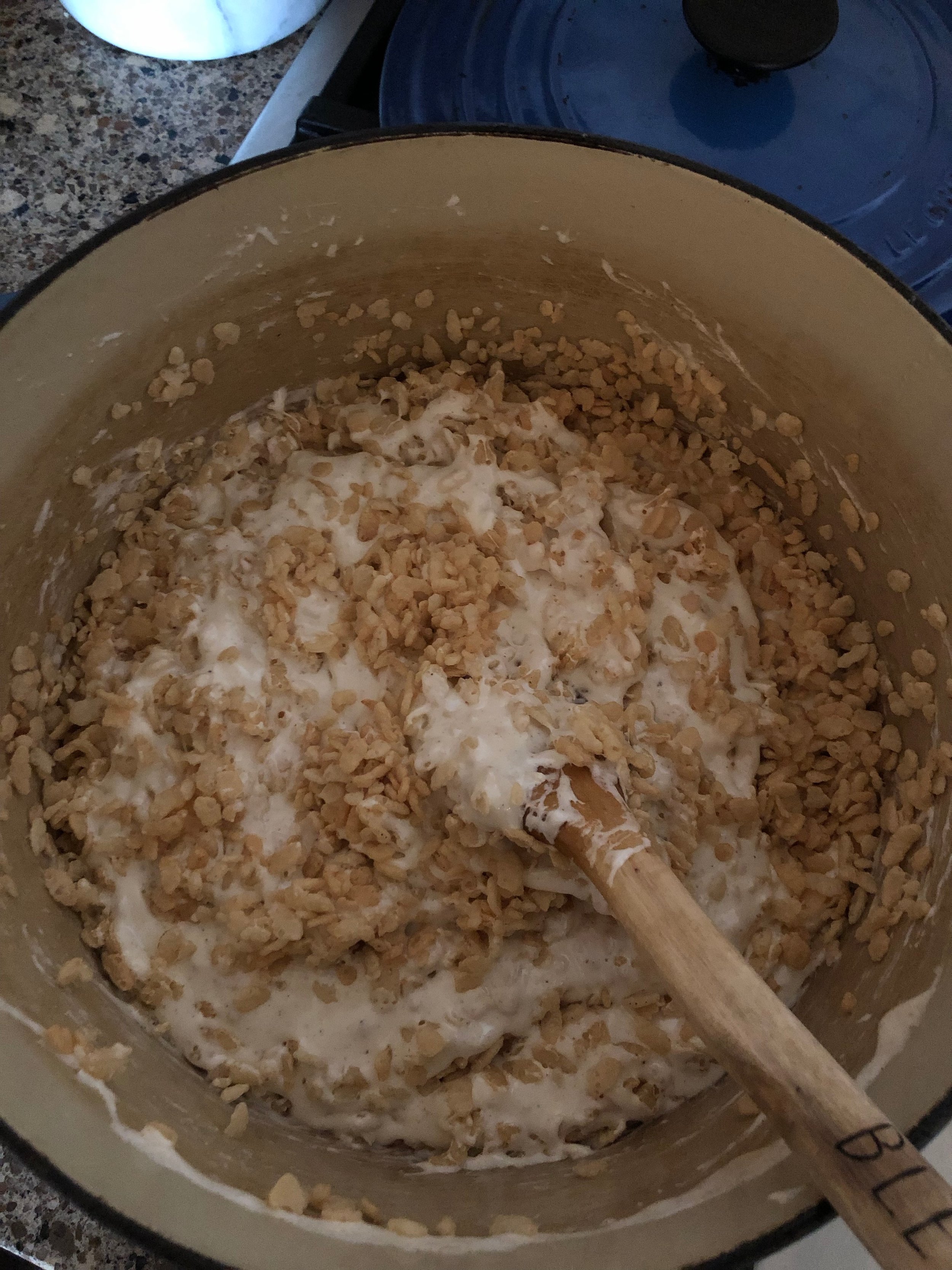 Gently folding the cereal into the brown butter marshmallow mixture