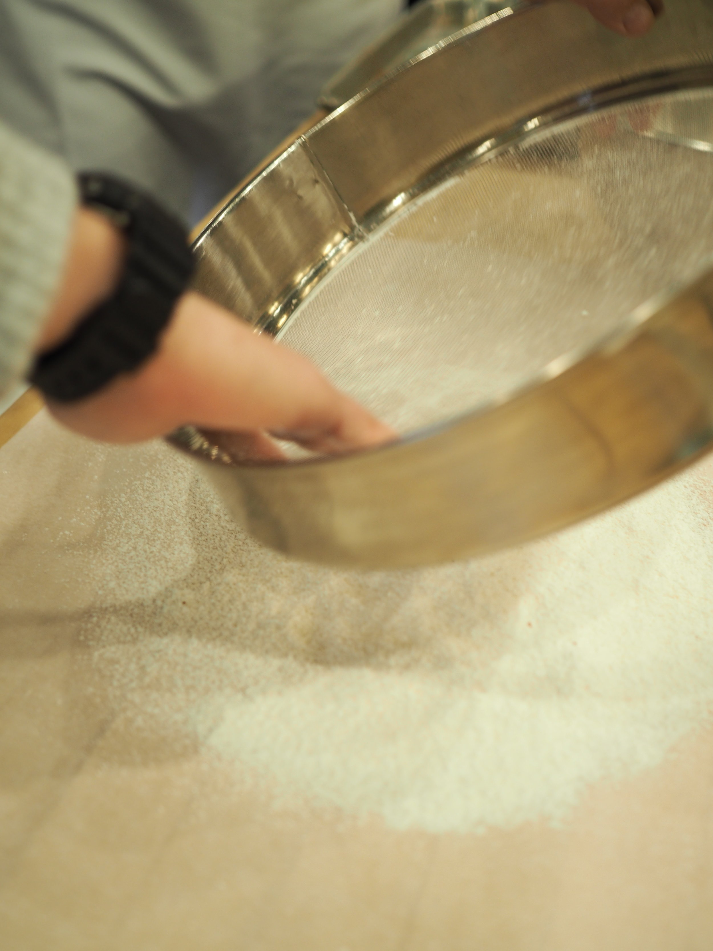 Sifting the almond flour and powdered sugar thrice