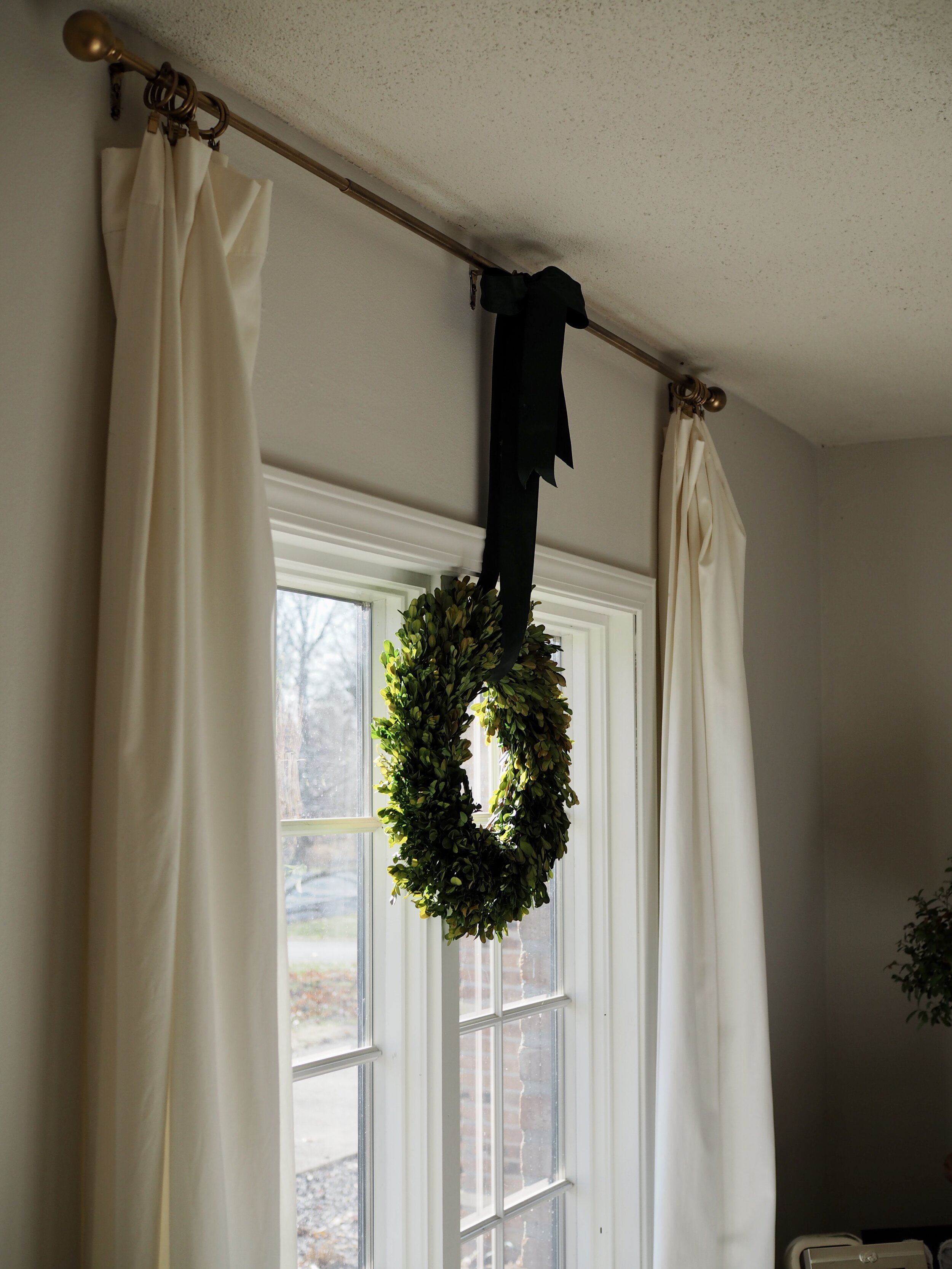Preserved boxwood wreaths hung on the living room windows