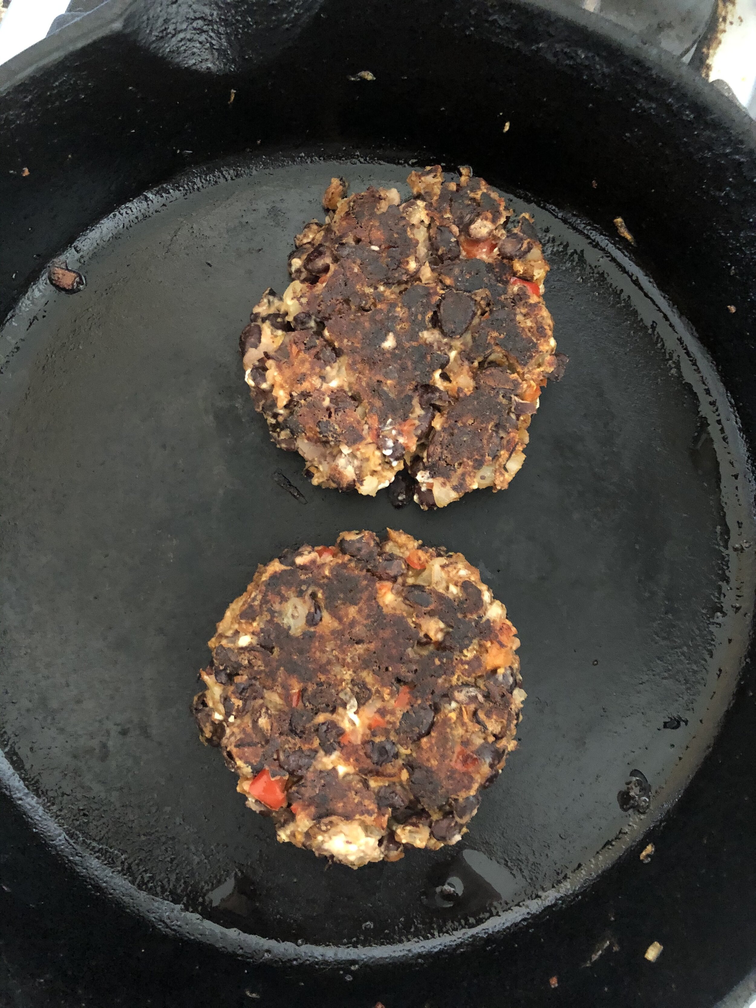 Seared black bean burgers in a cast iron skillet