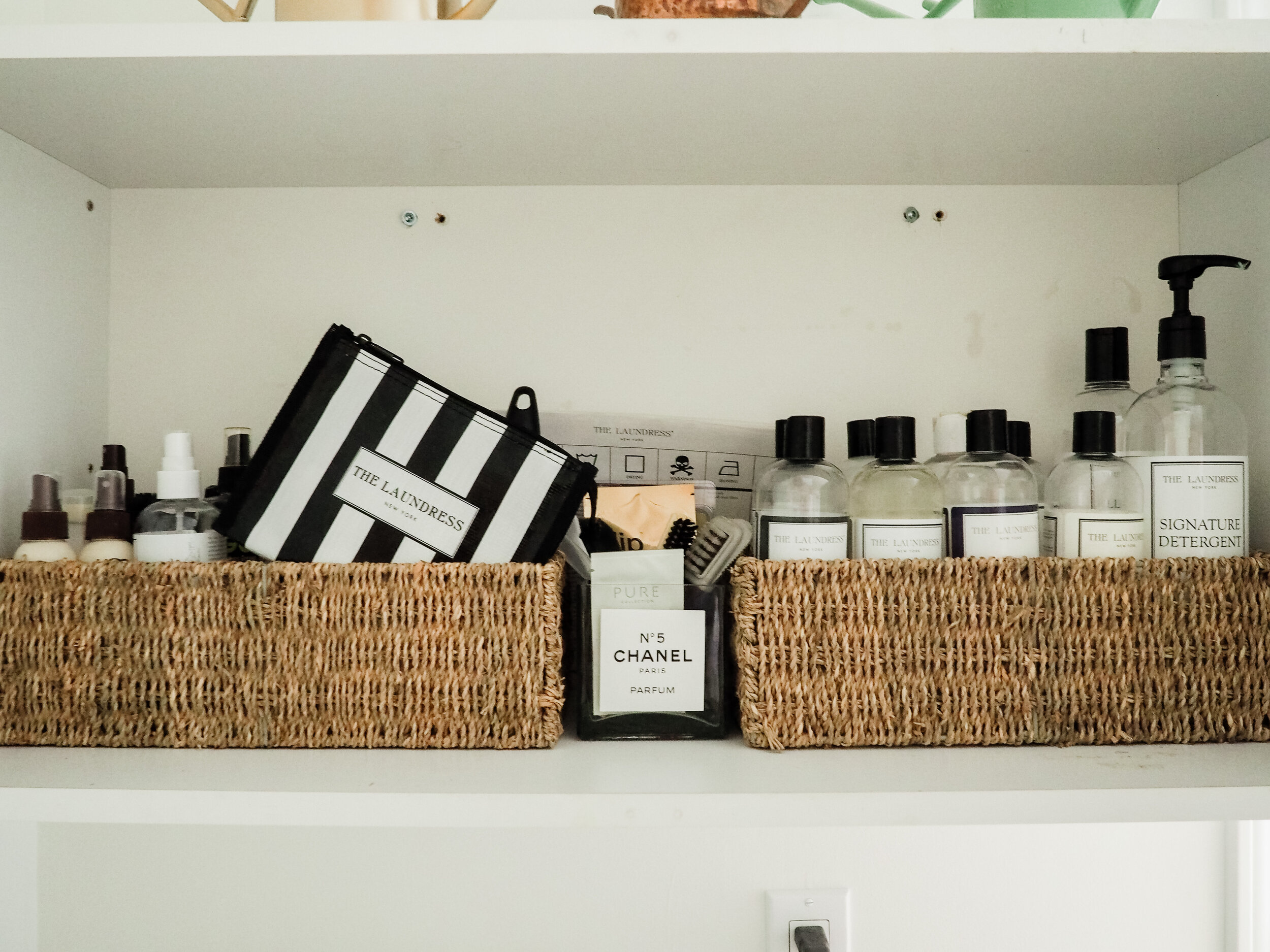 My favorite Laundress cleaning supplies inside the cabinet above the sink