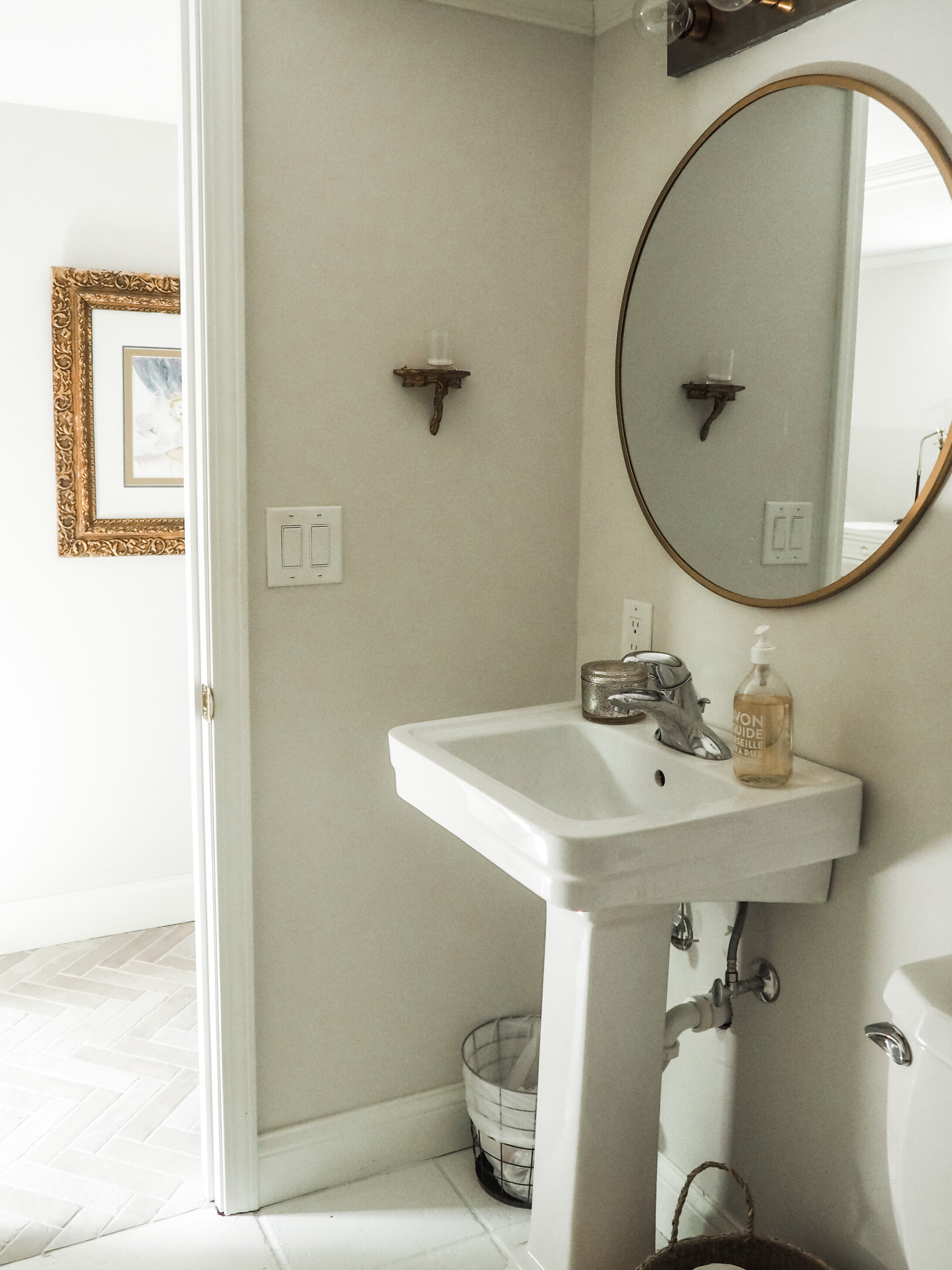 Simple white porcelain pedestal sink and a minimum of accessories