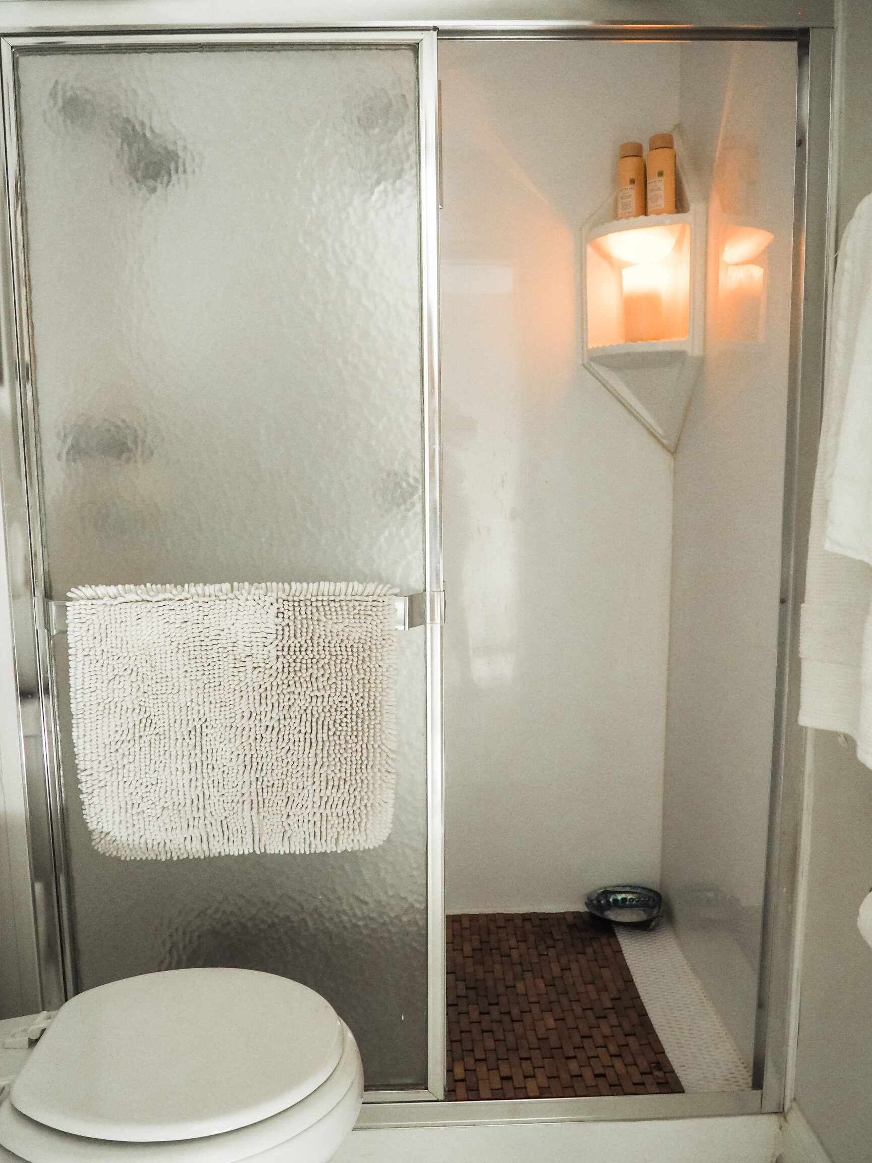 Bathroom after; a bamboo shower mat adds spa vibes to a fiberglass shower kit