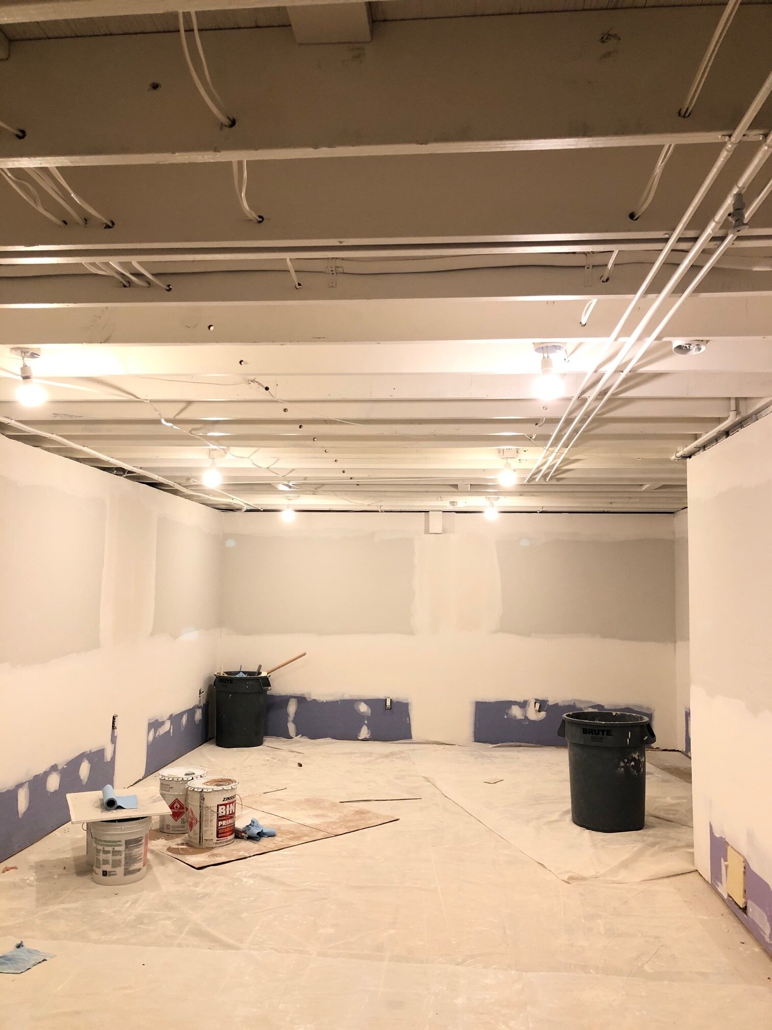 Instead of replacing the drop ceiling, we added a little height by keeping it open and spraying it all with a white shellac primer.