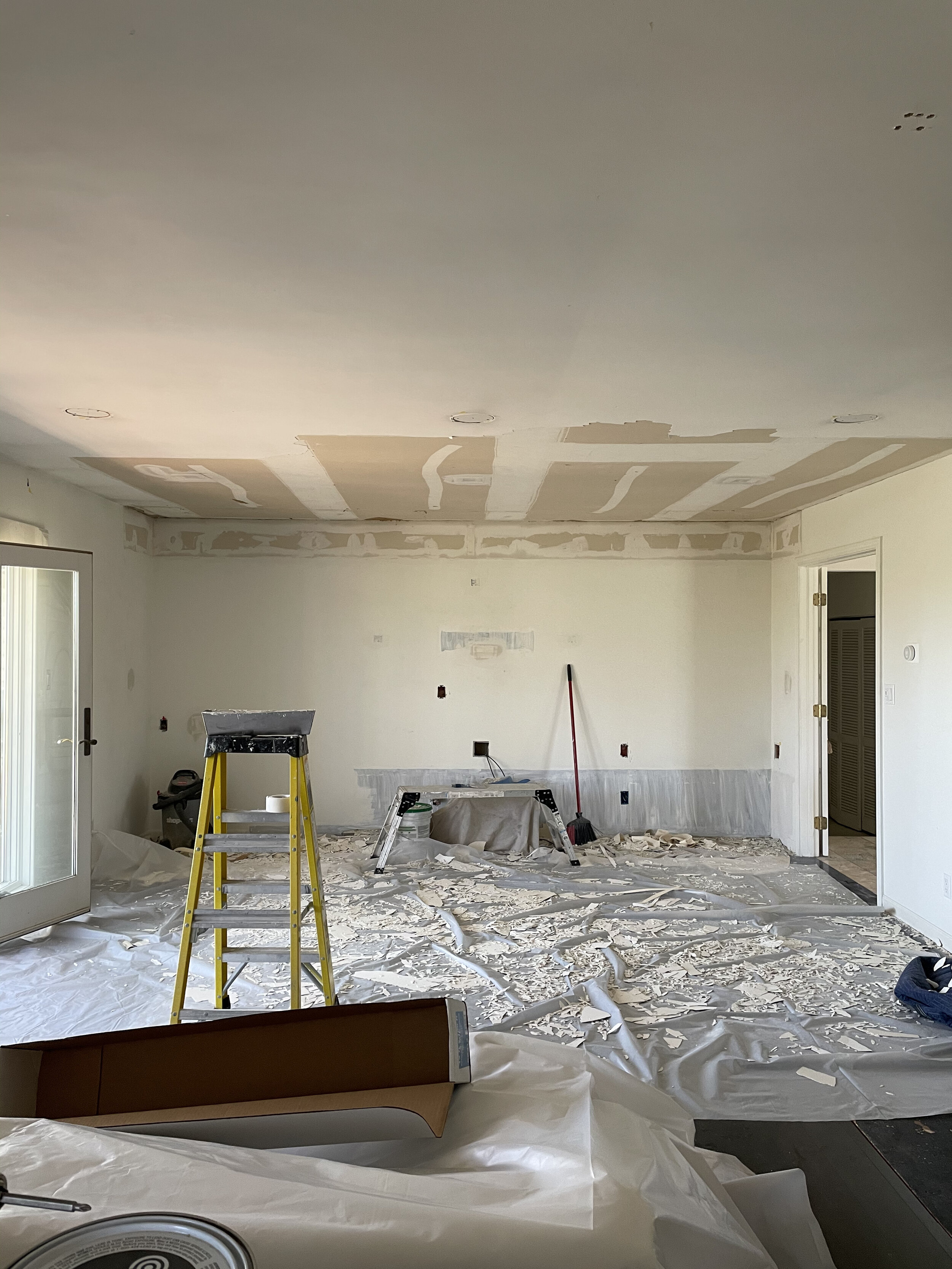 Scraping the old popcorn ceiling and patching the can light cutouts