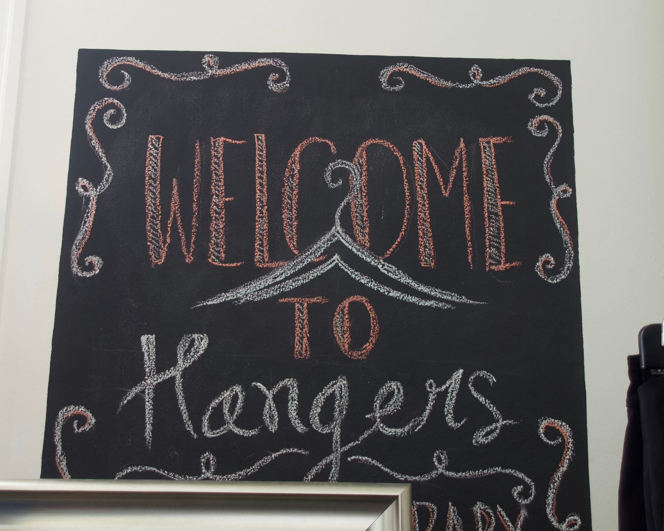 Welcome to Hangers chalkboard sign inside the resale boutique at Town Square Community Center.