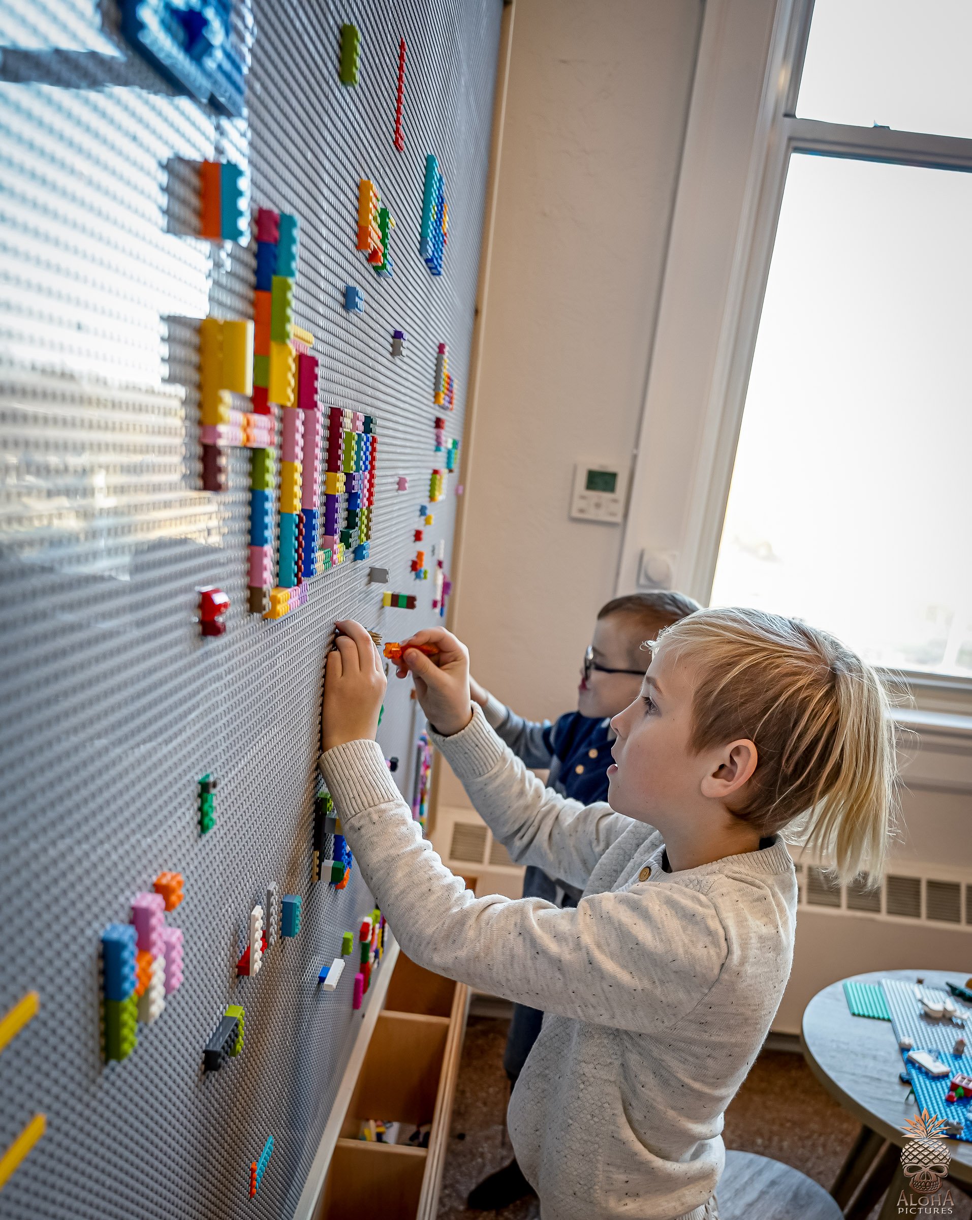 Child playing at the LEGO wall in The Hub indoor kids play space at Town Square Community Center.