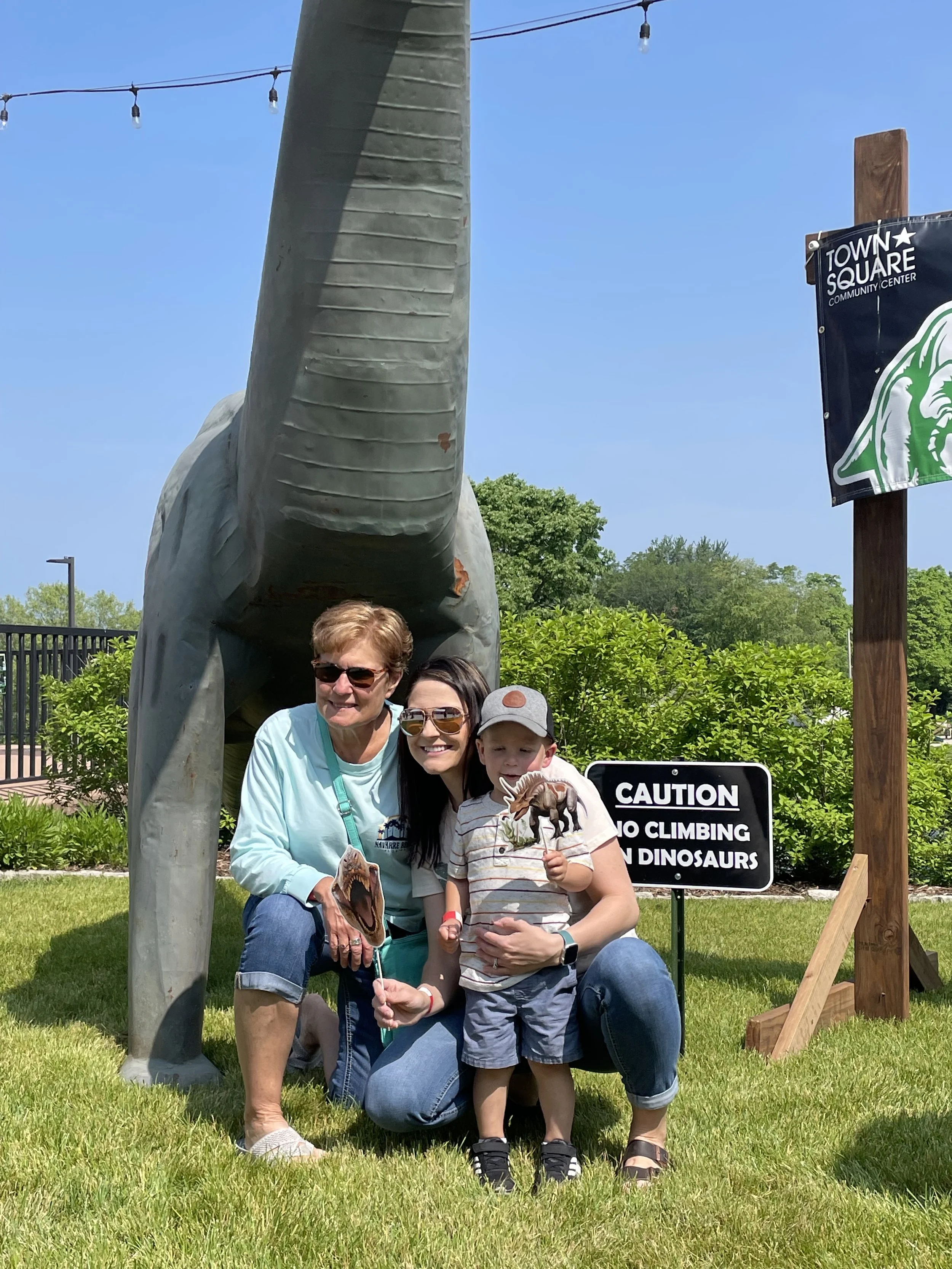 two adults with child in front of dino.jpeg