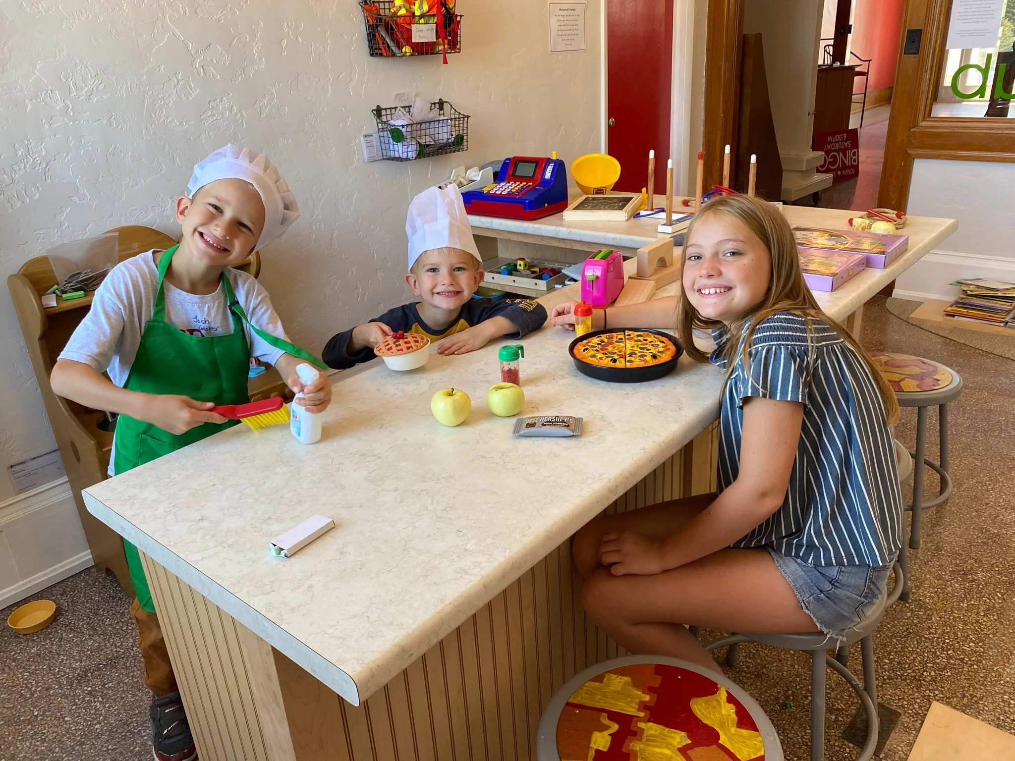 Children playing in the pretend kitchen at The Hub indoor play space in Green Lake, Wisconsin.