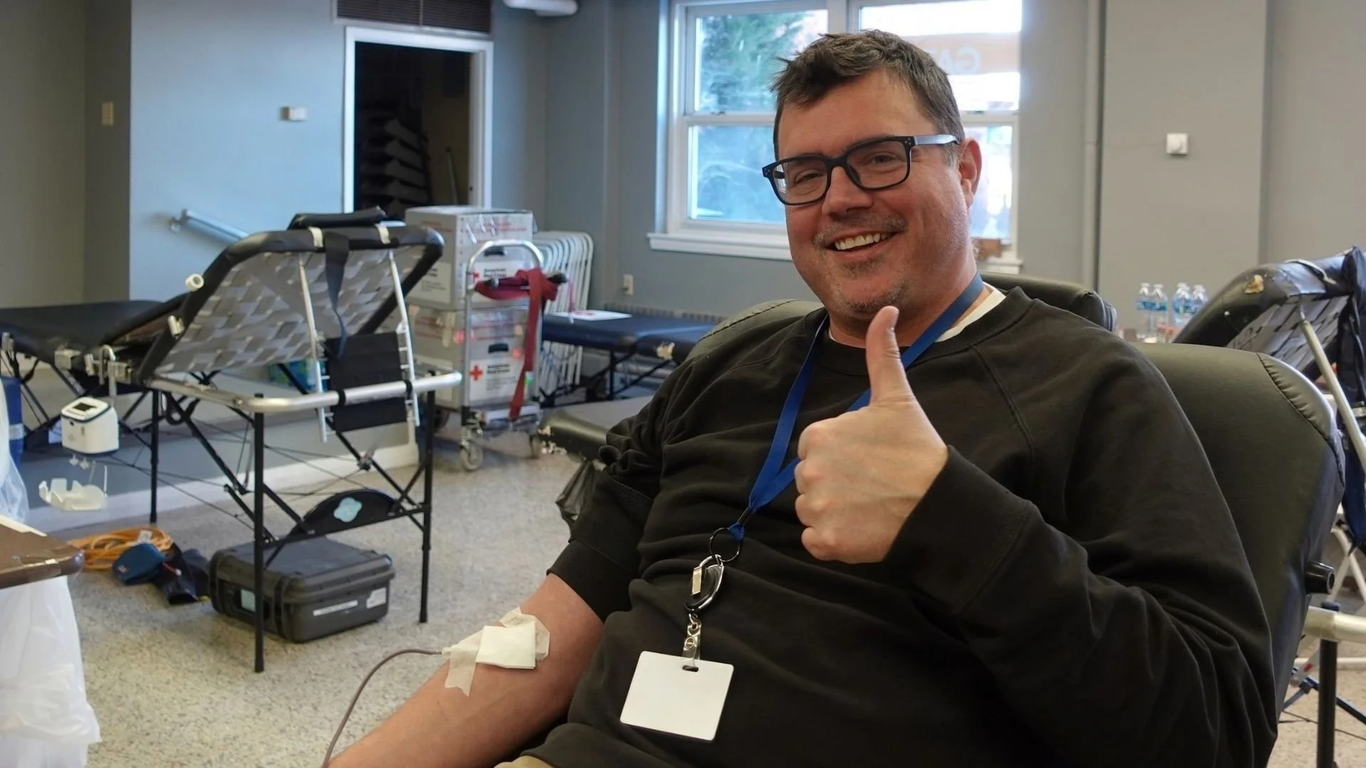 Blood donor gives a thumbs-up while donating blood during an American Red Cross blood drive at Town Square.
