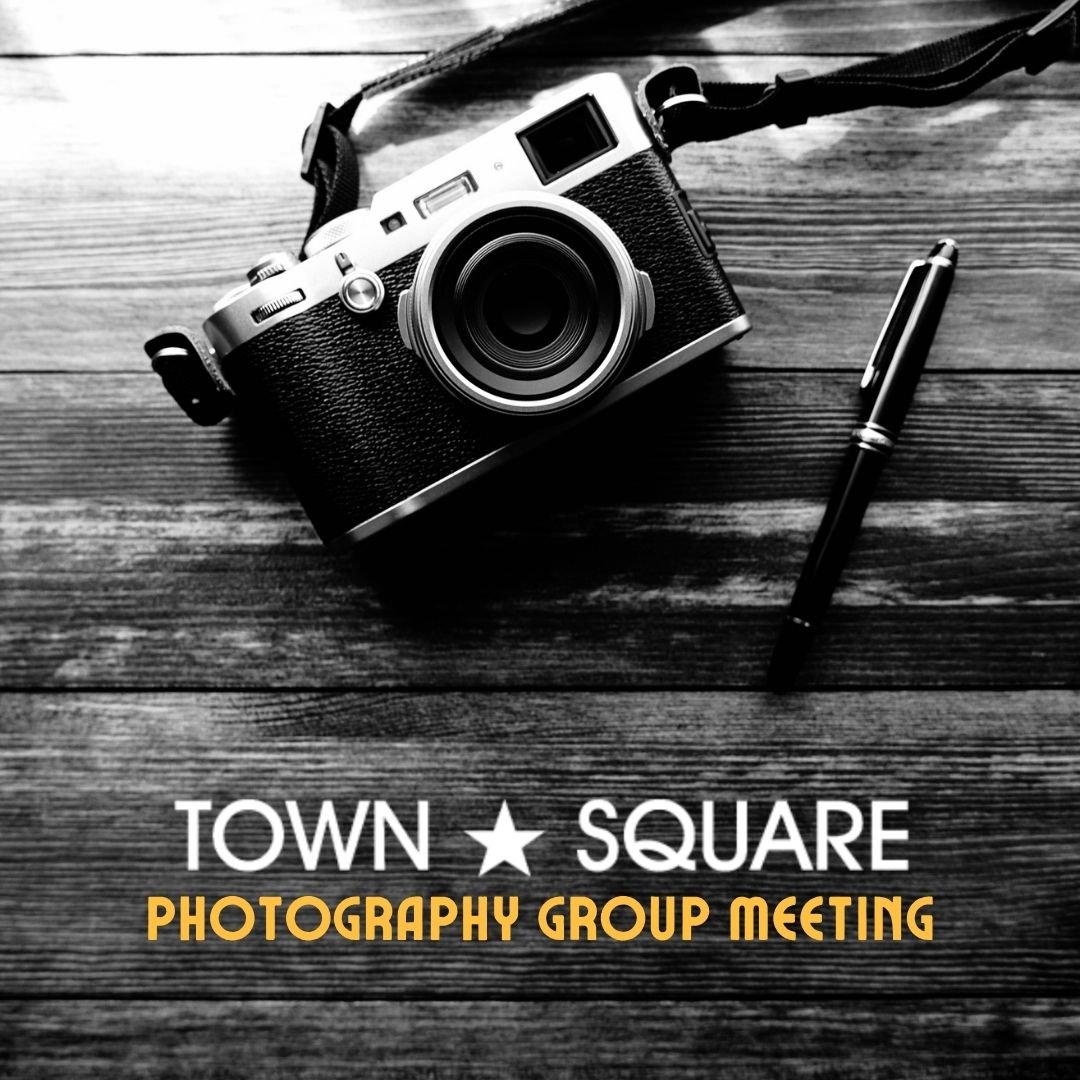 Town Square Photography Group graphic featuring a black-and-white camera and pen on a wooden table.