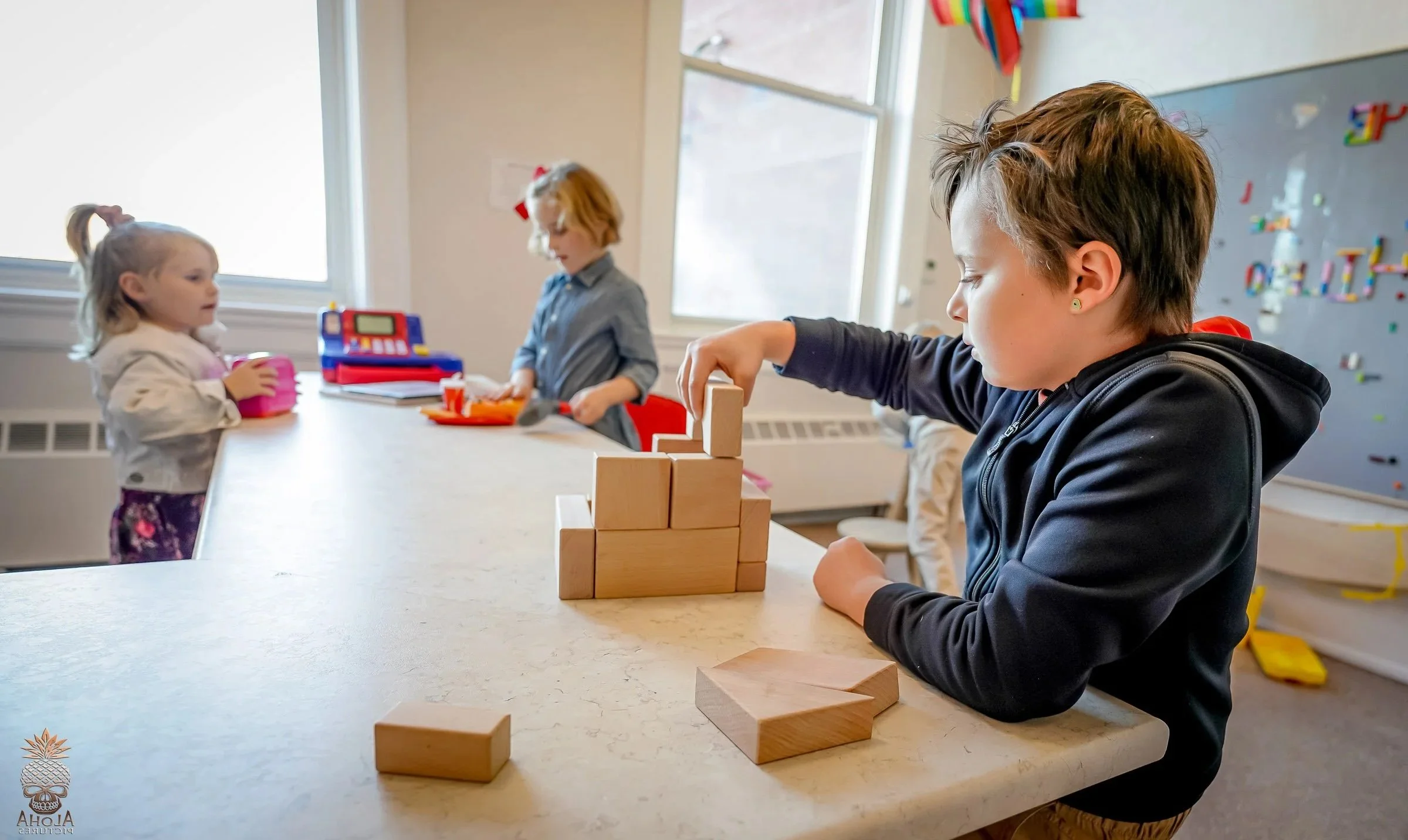 Child building with wooden blocks in The Hub, a free indoor play space at Town Square Community Center in Green Lake, Wisconsin.