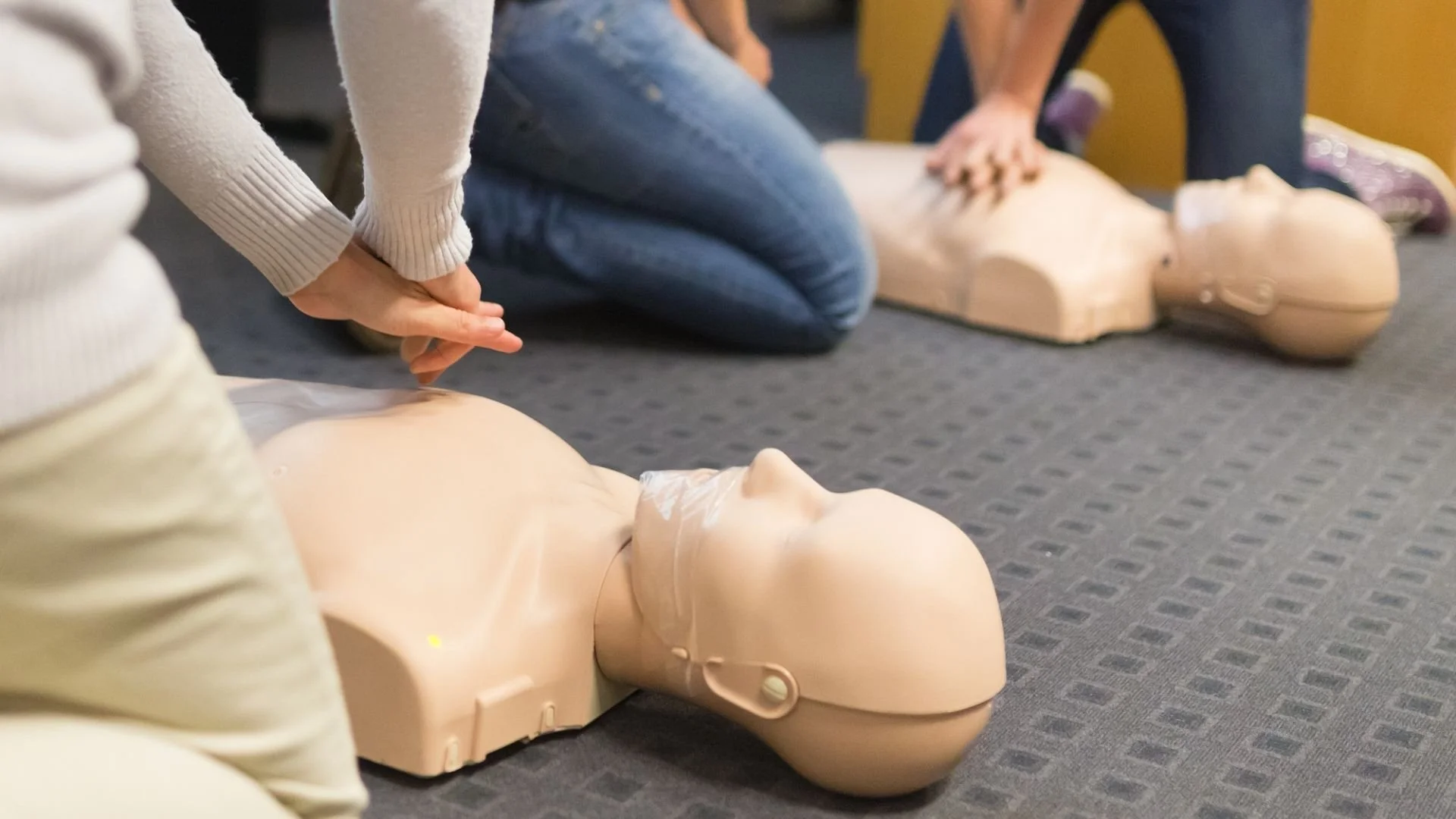 Participants practice chest compressions on CPR mannequins during a hands-on CPR training class.
