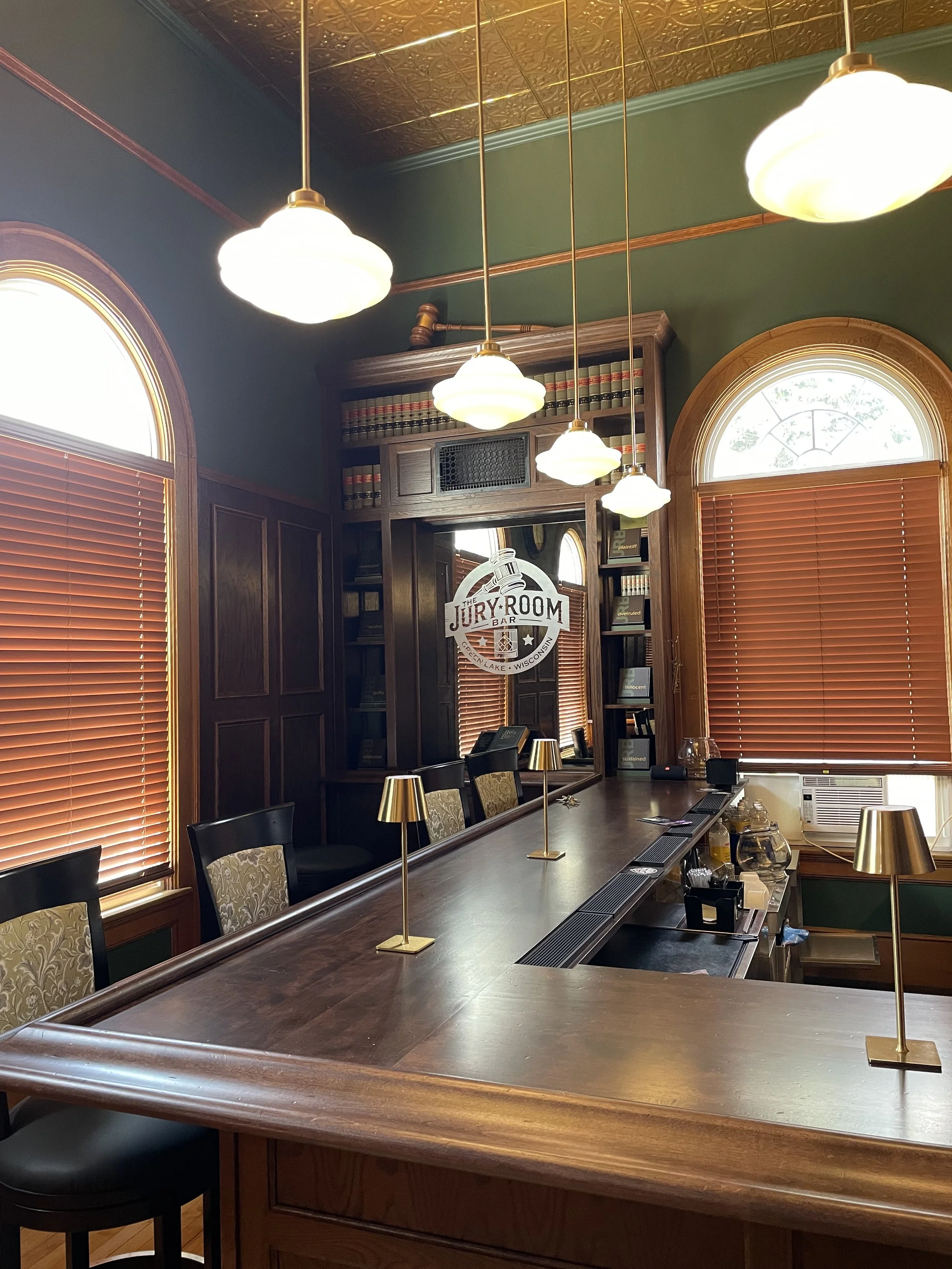 Historic Jury Room Bar inside Town Square Community Center featuring original woodwork, arched windows, and bar seating.