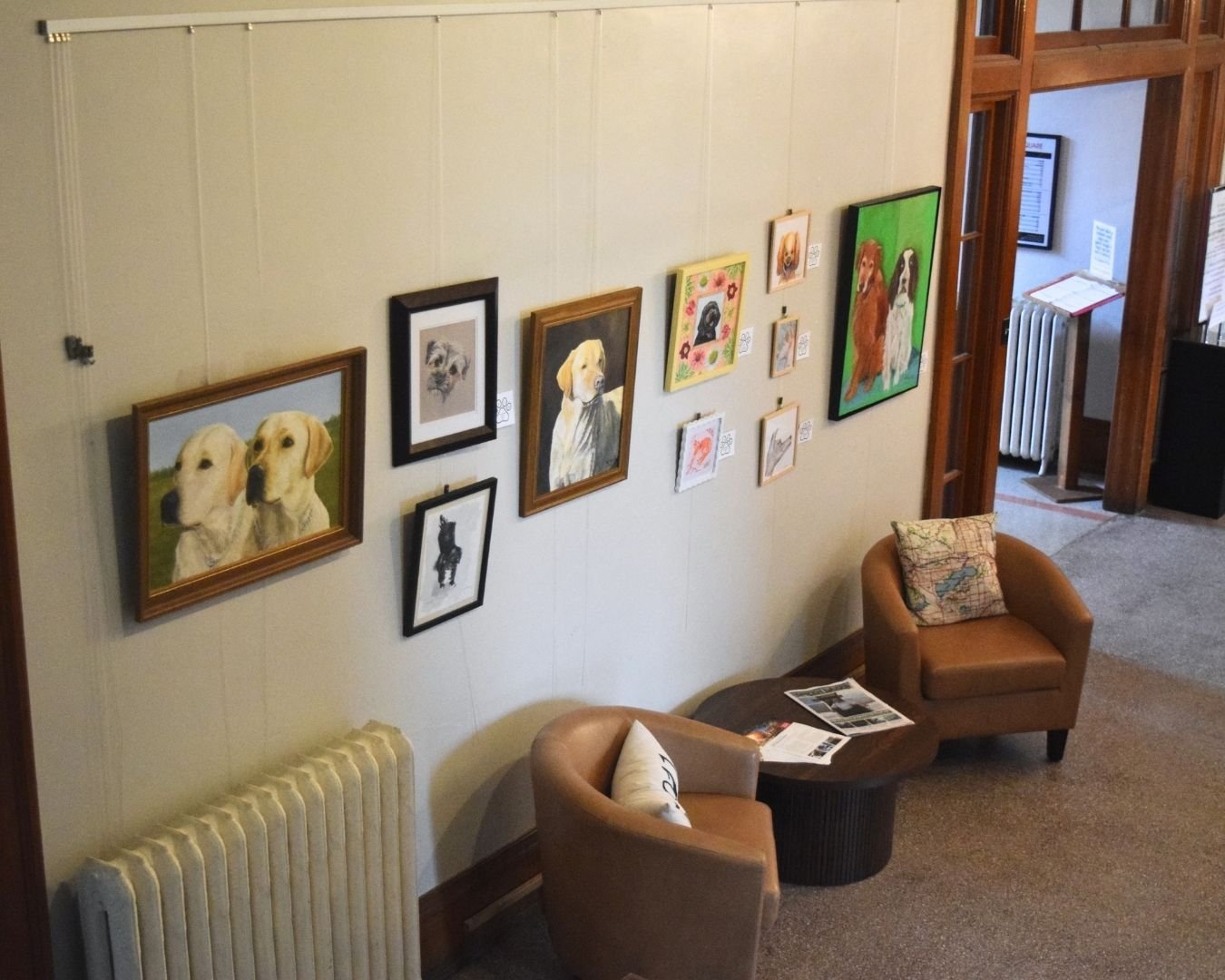 Pet-themed artwork displayed on the lobby gallery wall at Town Square Community Center.