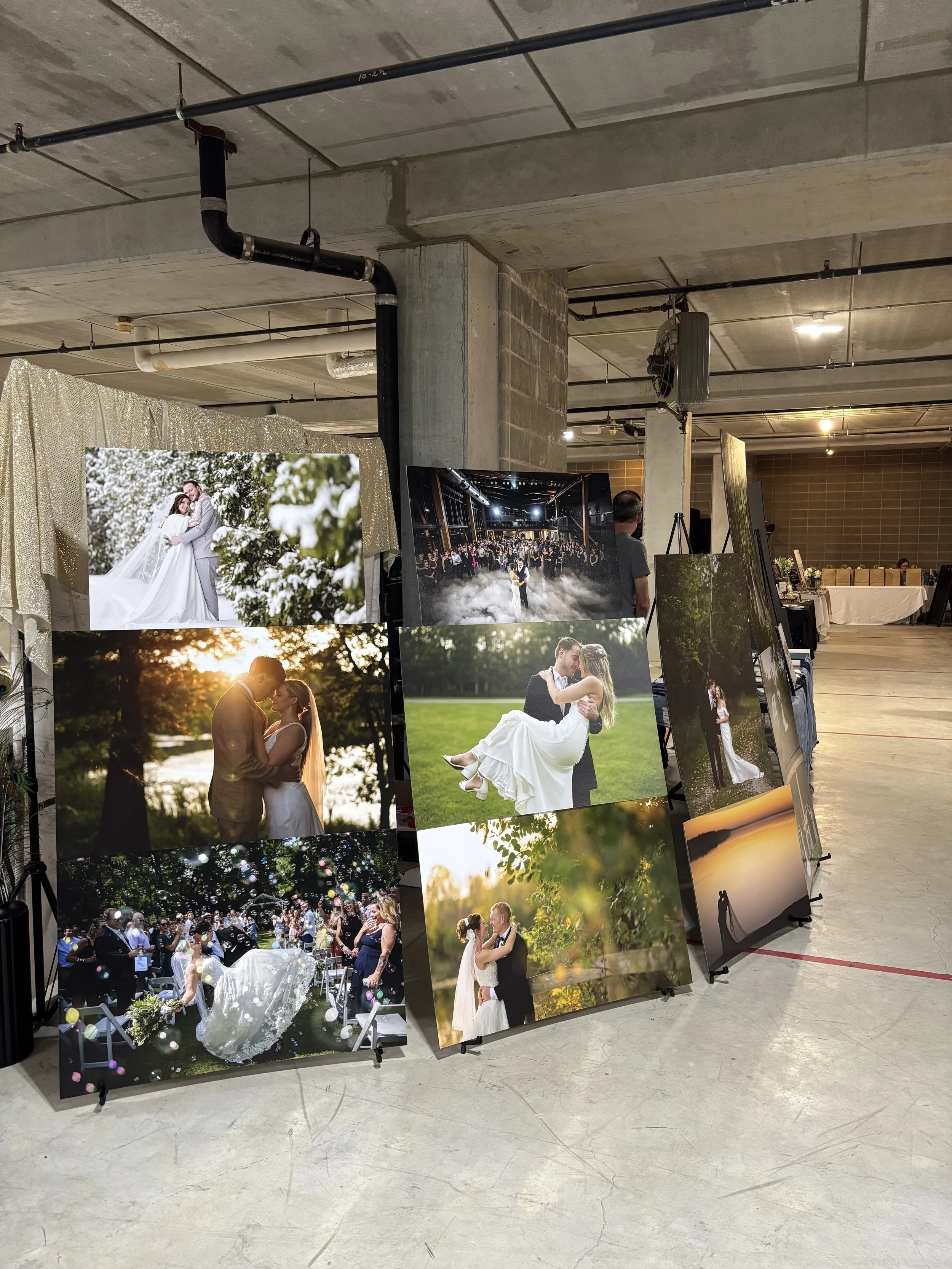 Large wedding photography prints featuring couples and wedding ceremonies displayed at a photographer's booth during the Wedding & Event Expo.