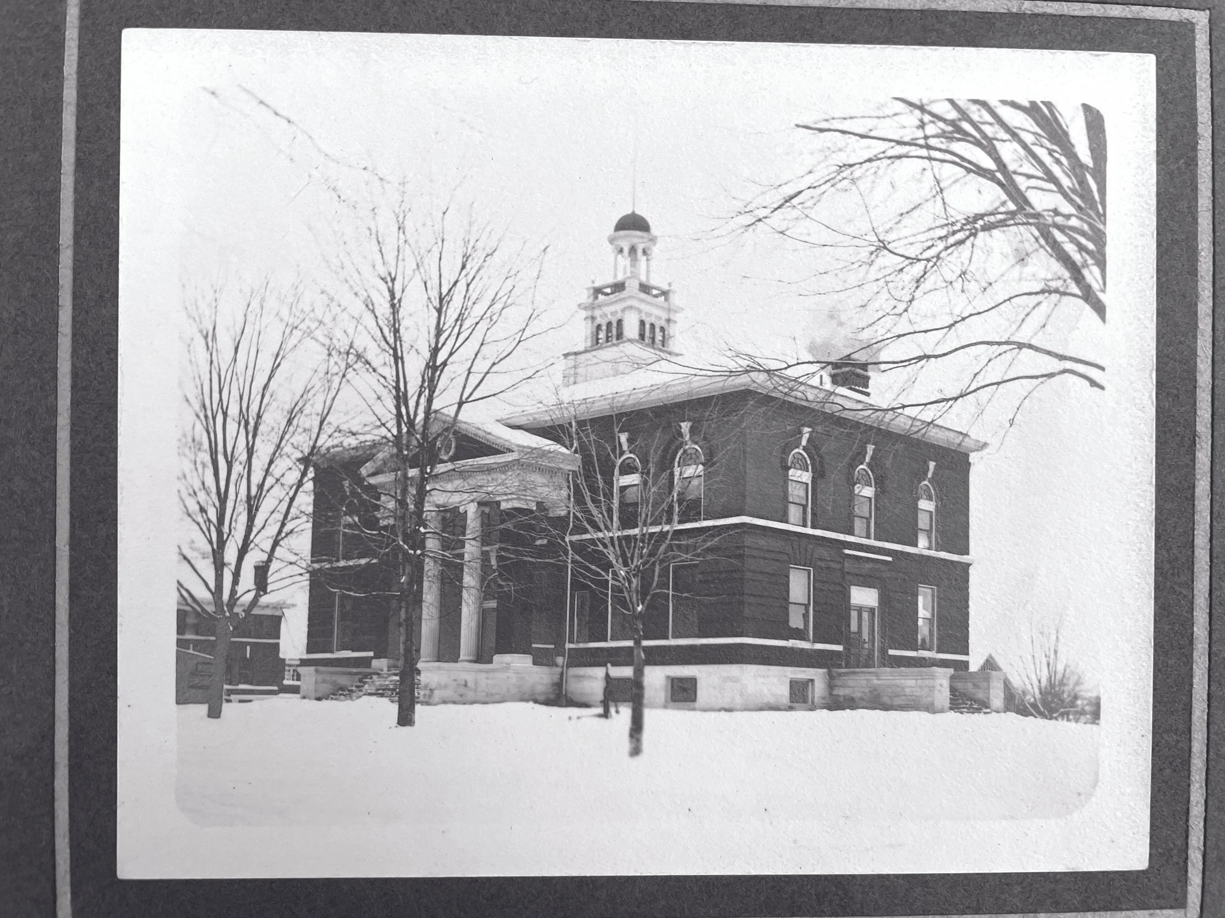 Construction began in 1899 on the new Neo-Classical courthouse, featuring a grand pedimented portico and prominent cupola. The County Board approved $25,000 in bonds to fund the project.