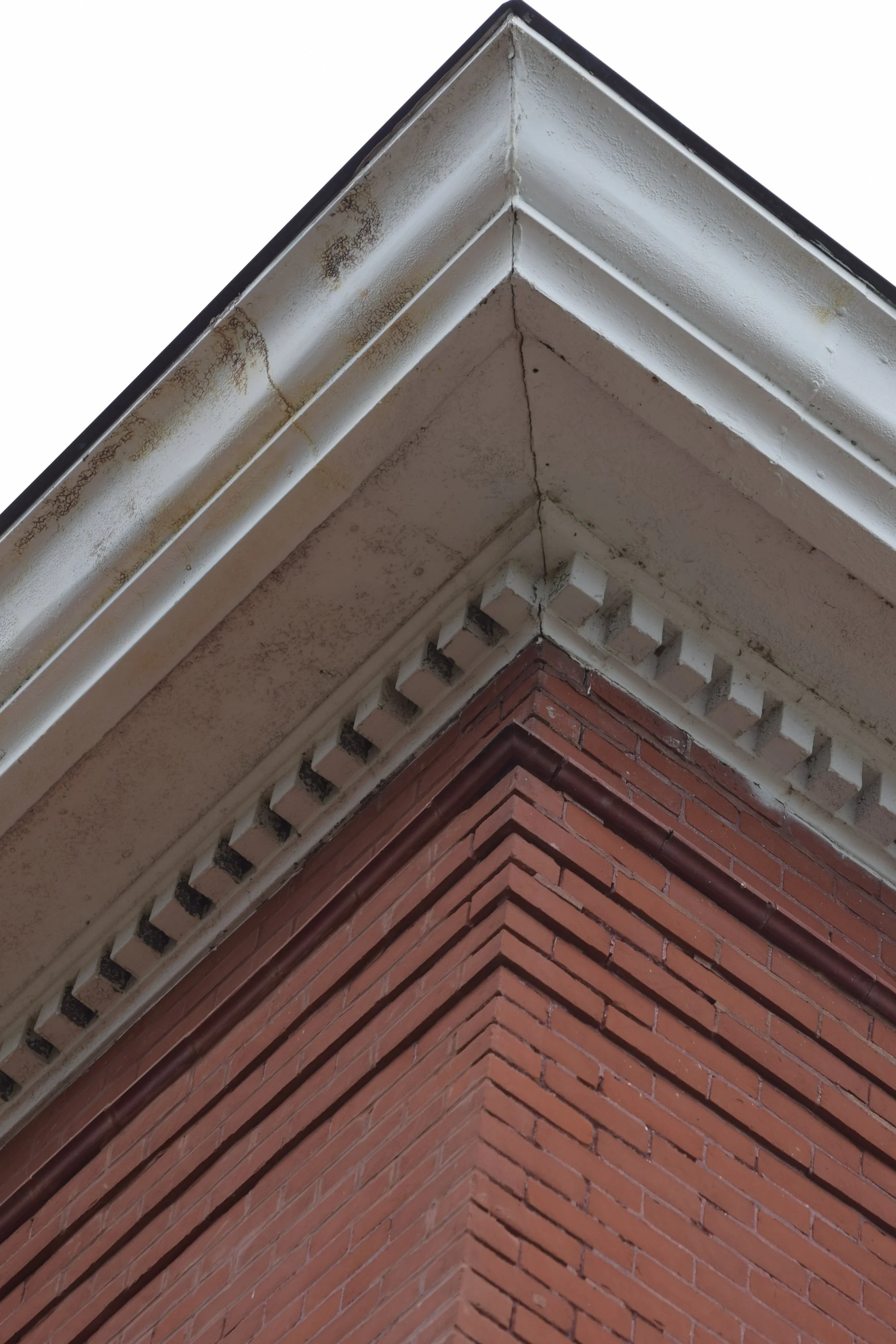 Close-up of the red brick and white architectural details along the roofline of the historic Town Square building.