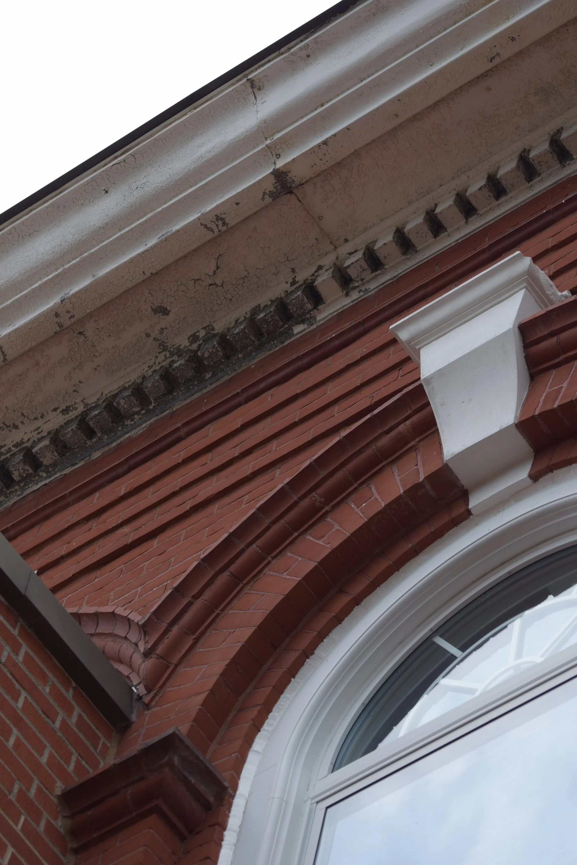 Close-up of aging paint and architectural details along the roofline of the historic Town Square building.