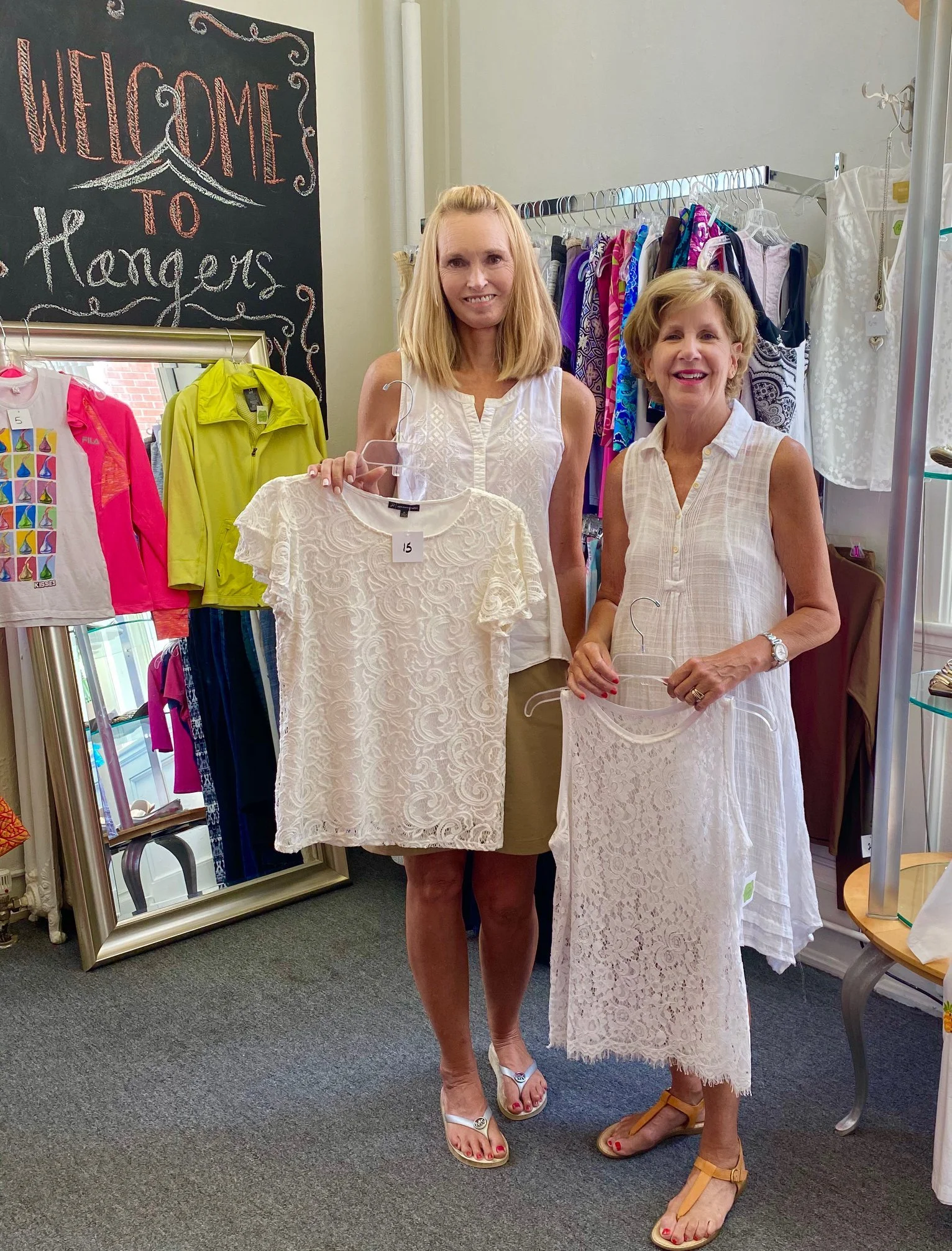 Volunteers holding shirts from Hangers Resale Shop.
