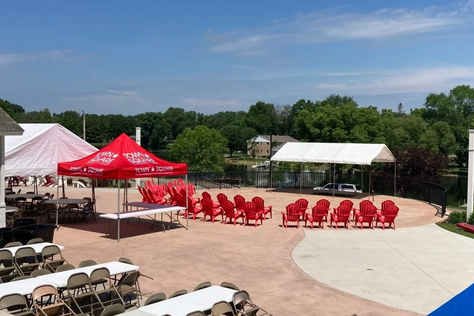 Mill Pond Terrace at Town Square Community Center with outdoor seating, tents, and views of the Mill Pond in Green Lake.