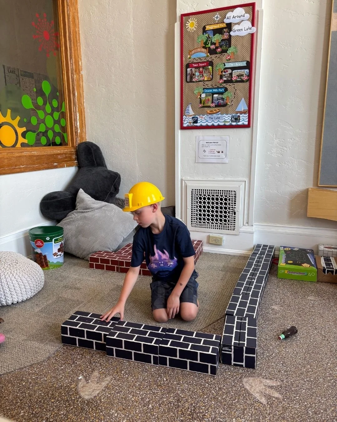 Child enjoying hands-on play in The Hub at Town Square Community Center in downtown Green Lake.
