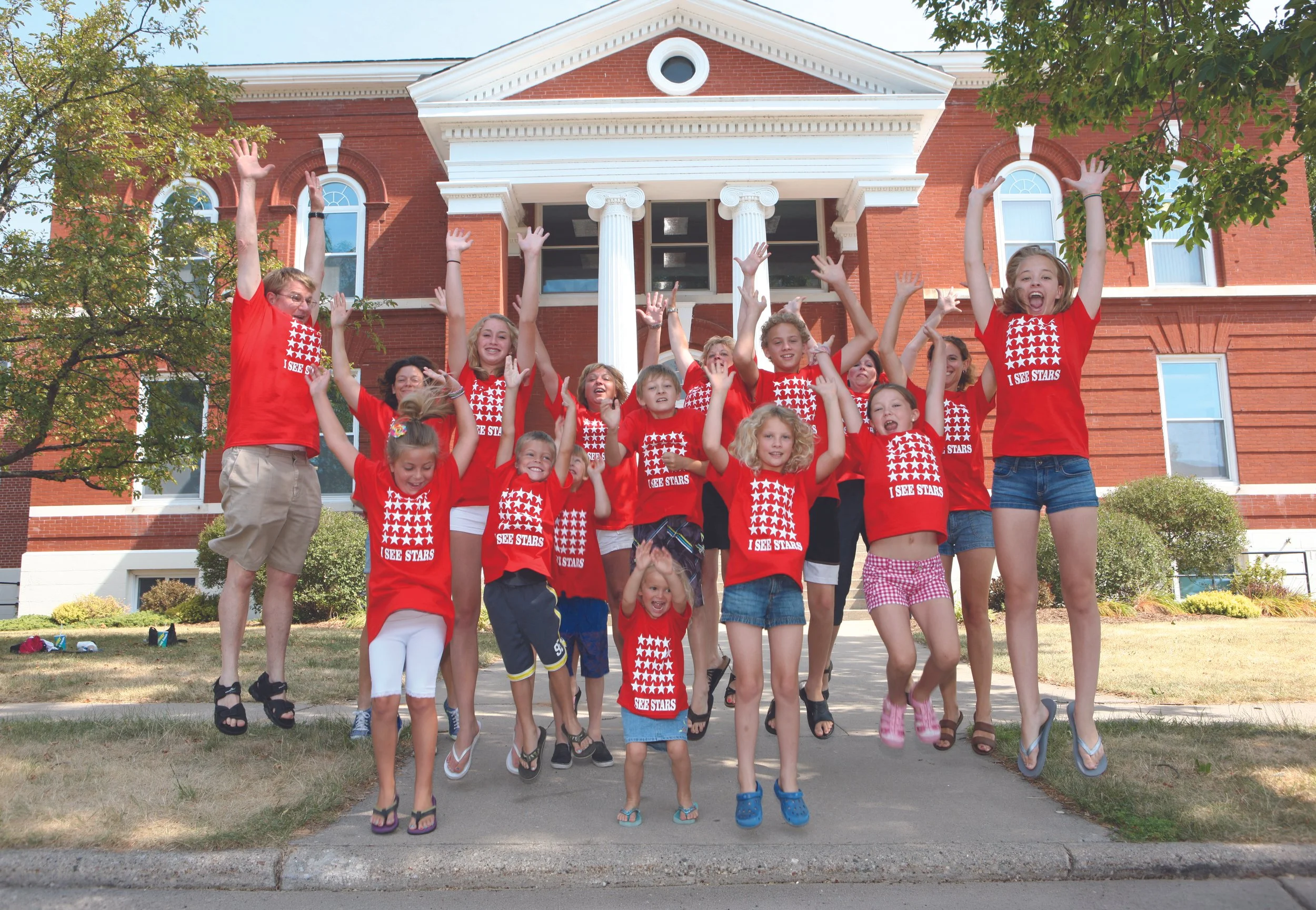 Children and adults jump together outside Town Square during the community center’s early years, capturing the energy and excitement surrounding its new chapter.