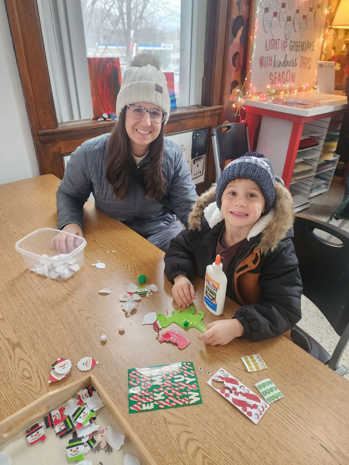 Child and adult create festive holiday crafts together at Town Square Community Center.