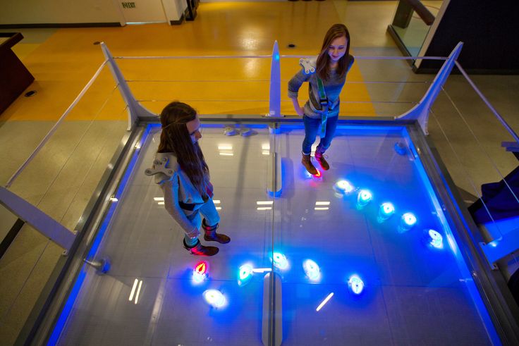 Hannah Lawrence, left, and Rachel Lawrence playing Robot Swarm, an exhibit in which one can control the movement of differently colored robots. Ozier Muhammad / The New York Times