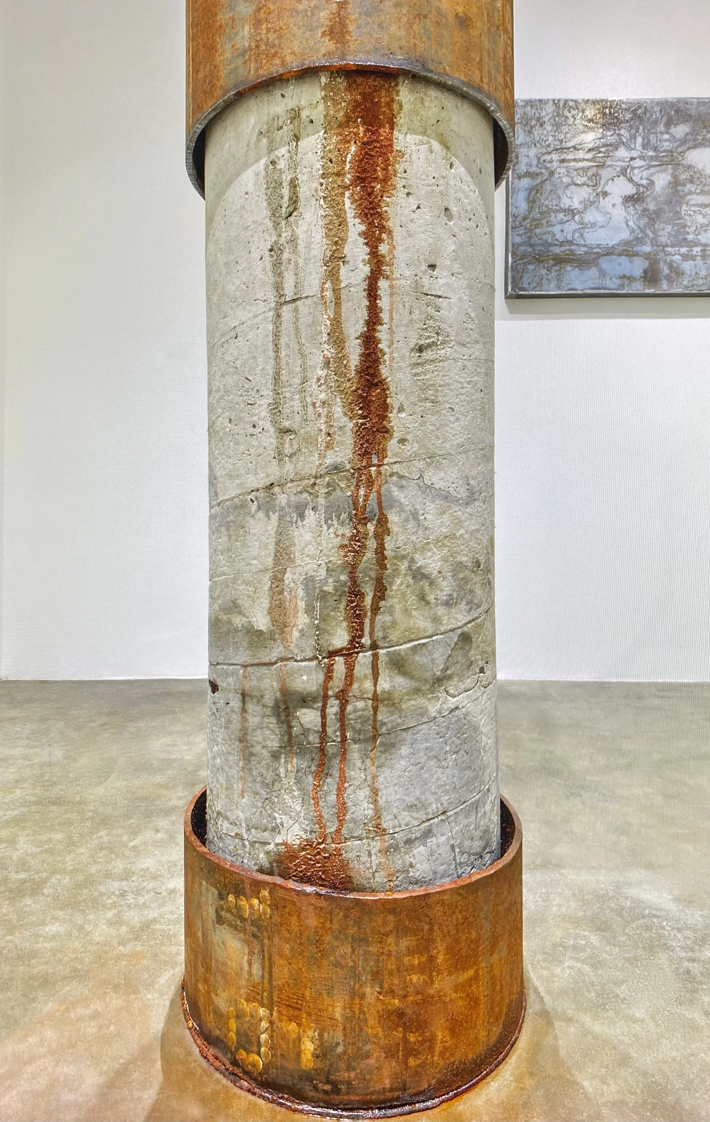 Exhibition final results of oxidized steel weathering the side of the stone pillar.