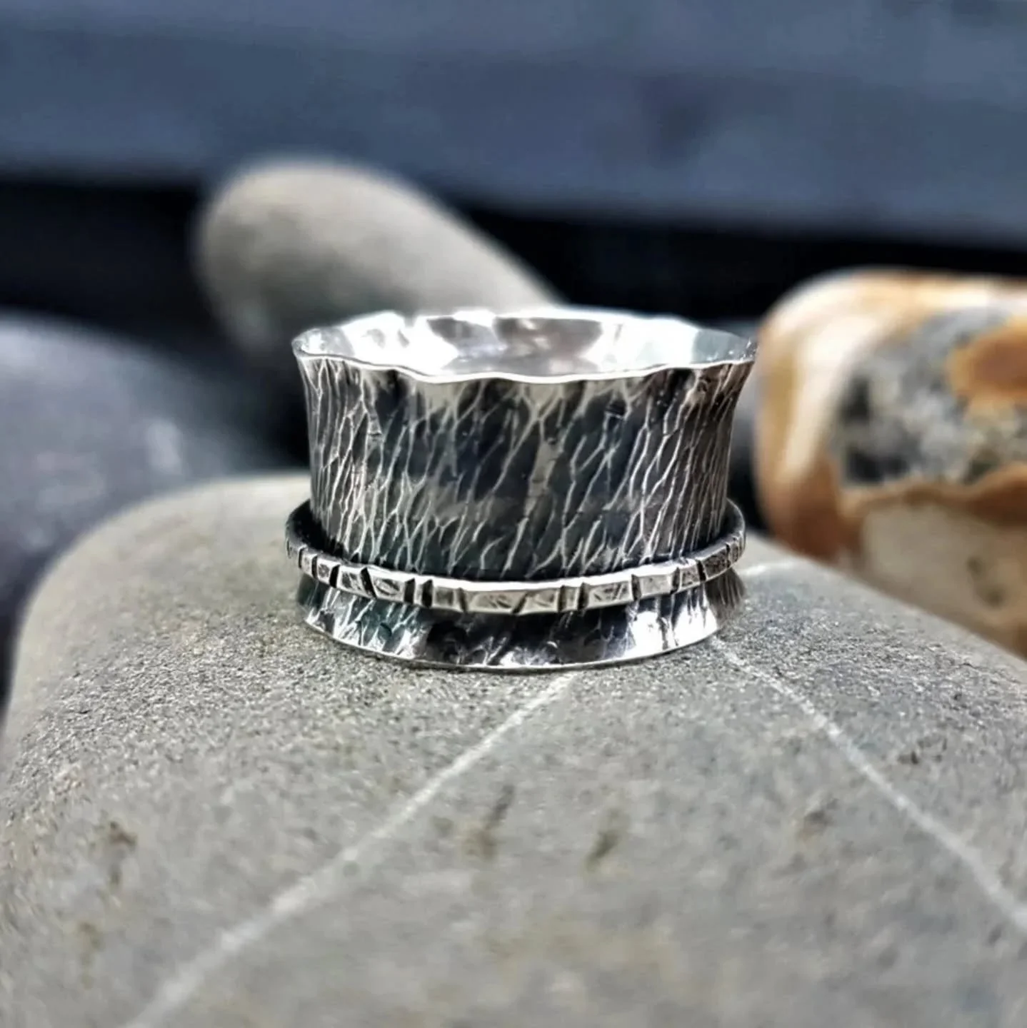Just showing off a spinner ring from my shop today..chunky, flared edges, texture, oxidised and polished 💓 This one sits  between an O 1/2 and a Q 1/2 because it's a wide band.

https://www.ilovedollyjewellery.co.uk/rings/textured-silver-spinner-wav
