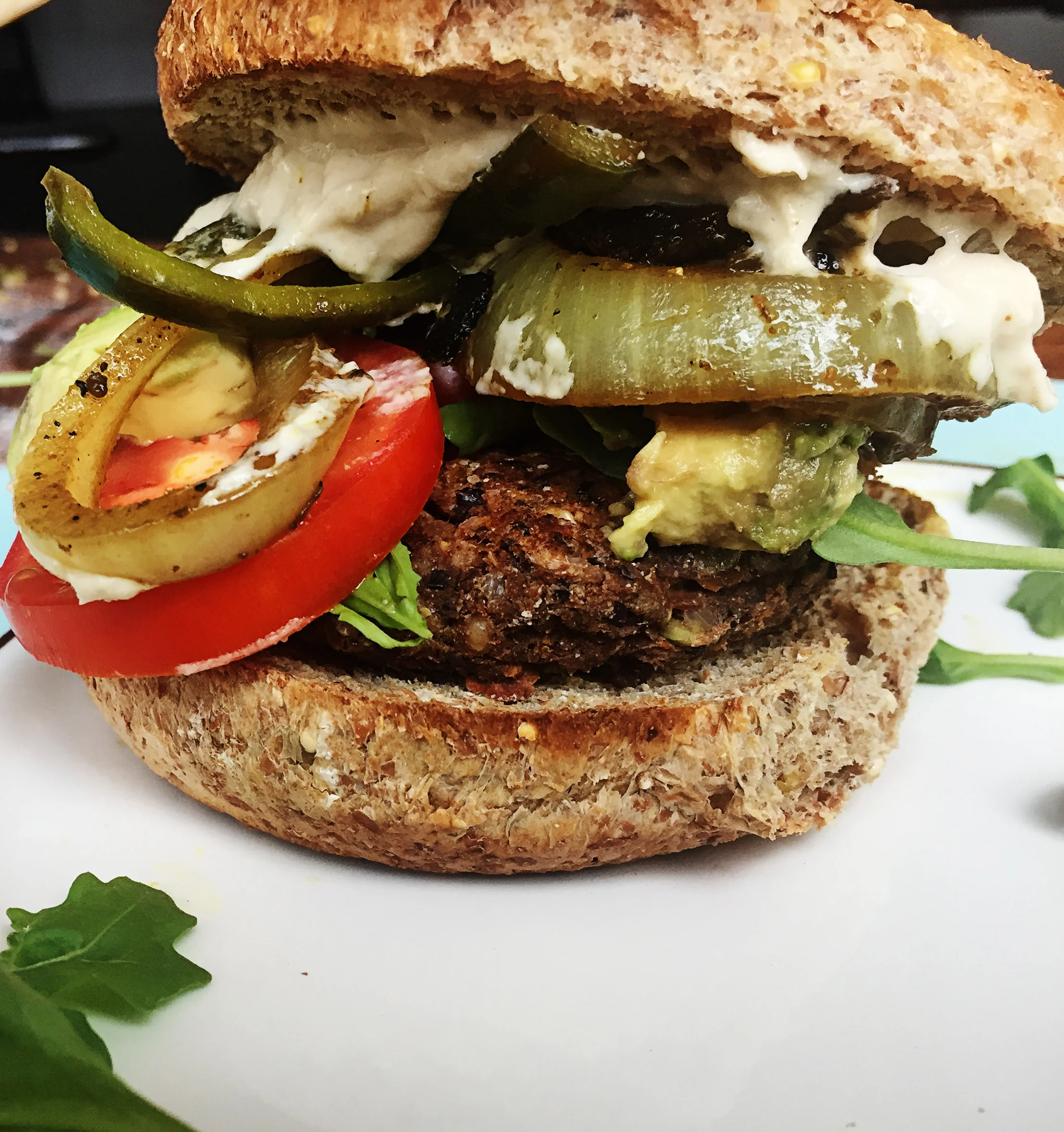 8. Serve the burger on gluten free bun. I like to stack the patty, arugula, tomato, caramelized veggies, and spread. Enjoy!